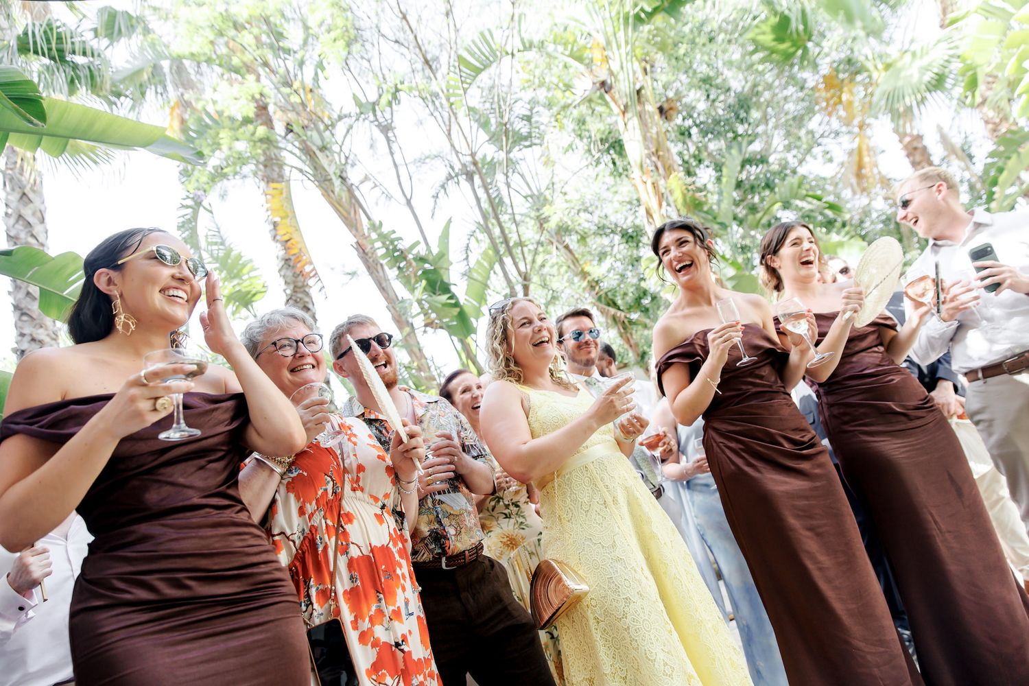 Bridesmaids in brown strapless gowns celebrate outdoors at an elegant wedding venue in Spain