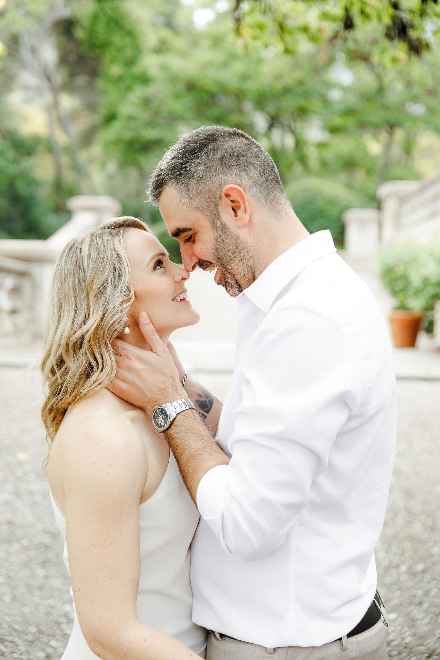 A couple shares a gentle kiss in the green park of Palau de les Heures, Barcelona.