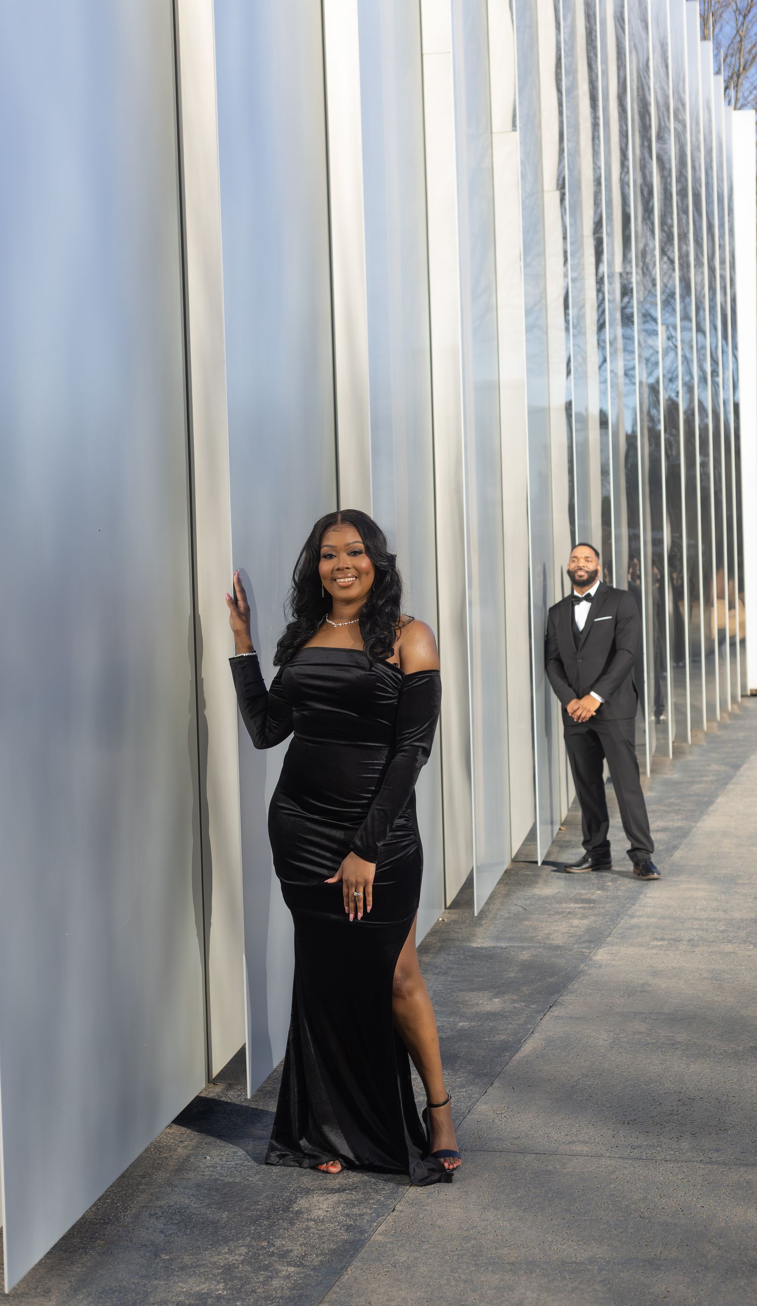 Wedding photoshoot with couple posing between modern silver pillars.