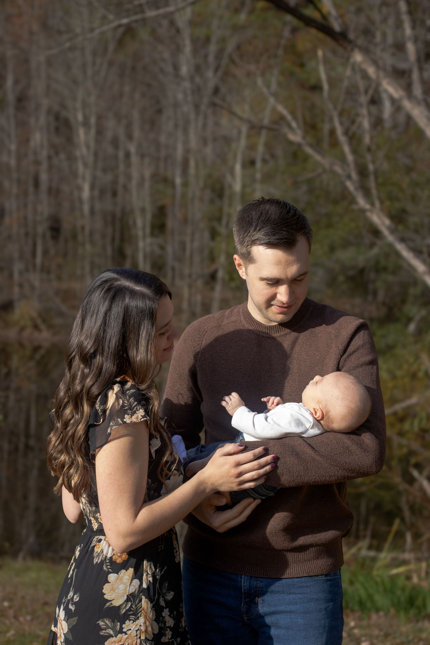 Outdoor family photoshoot in wooded area with natural lighting.