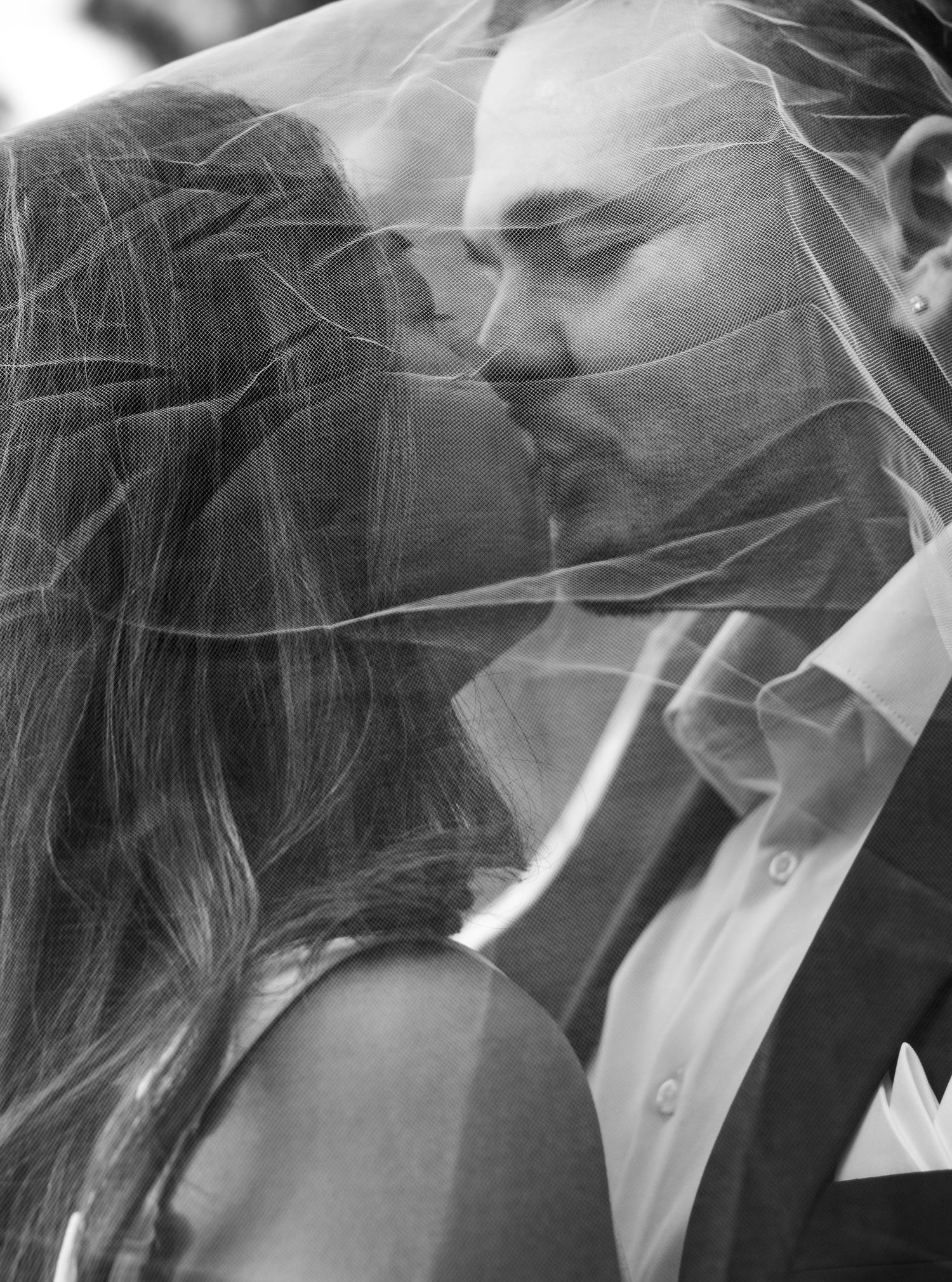 An intimate black and white portrait of a couple sharing a tender moment.