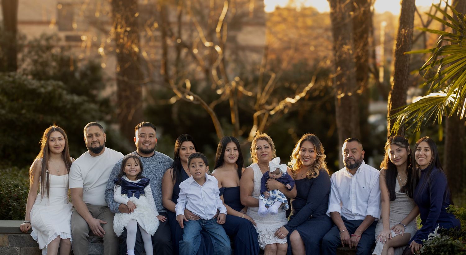 Extended family portrait session at sunset in coordinated navy and white outfits.