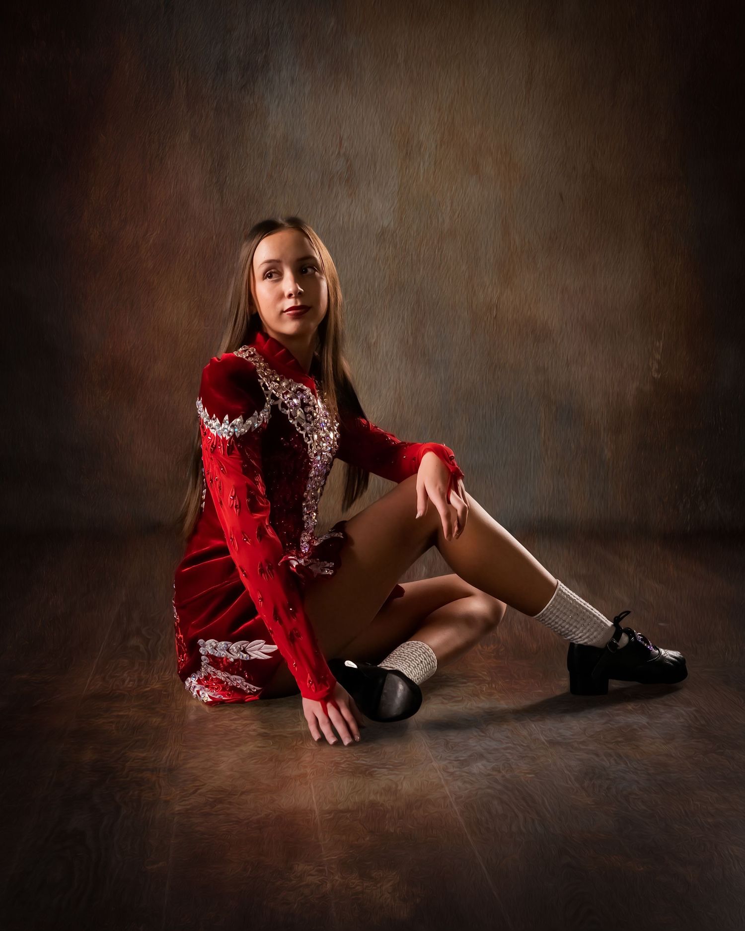 Young girl in red Irish dance costume with white socks and black shoes poses on studio floor.