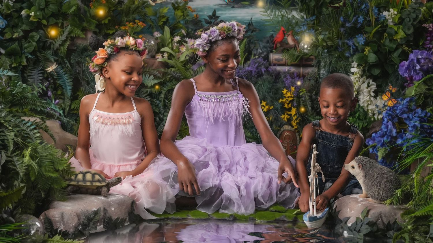 Three young girls in tutu dresses and flower crowns pose in a lush fairy garden photography set.