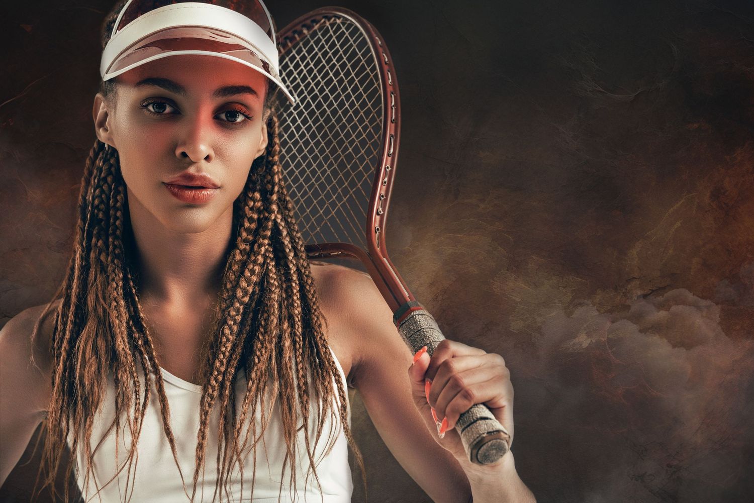 Young female tennis player with braids and visor holds racket confidently against smoky dark background.
