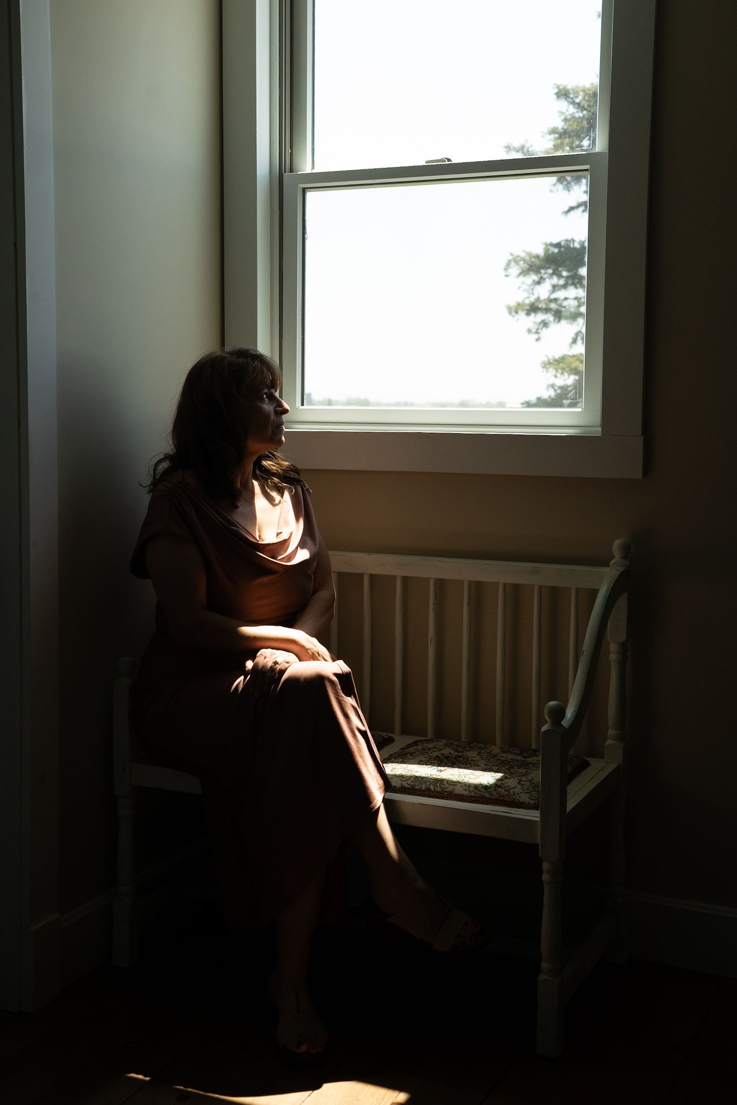 Moody silhouette portraits near a window create dramatic lighting and shadows.