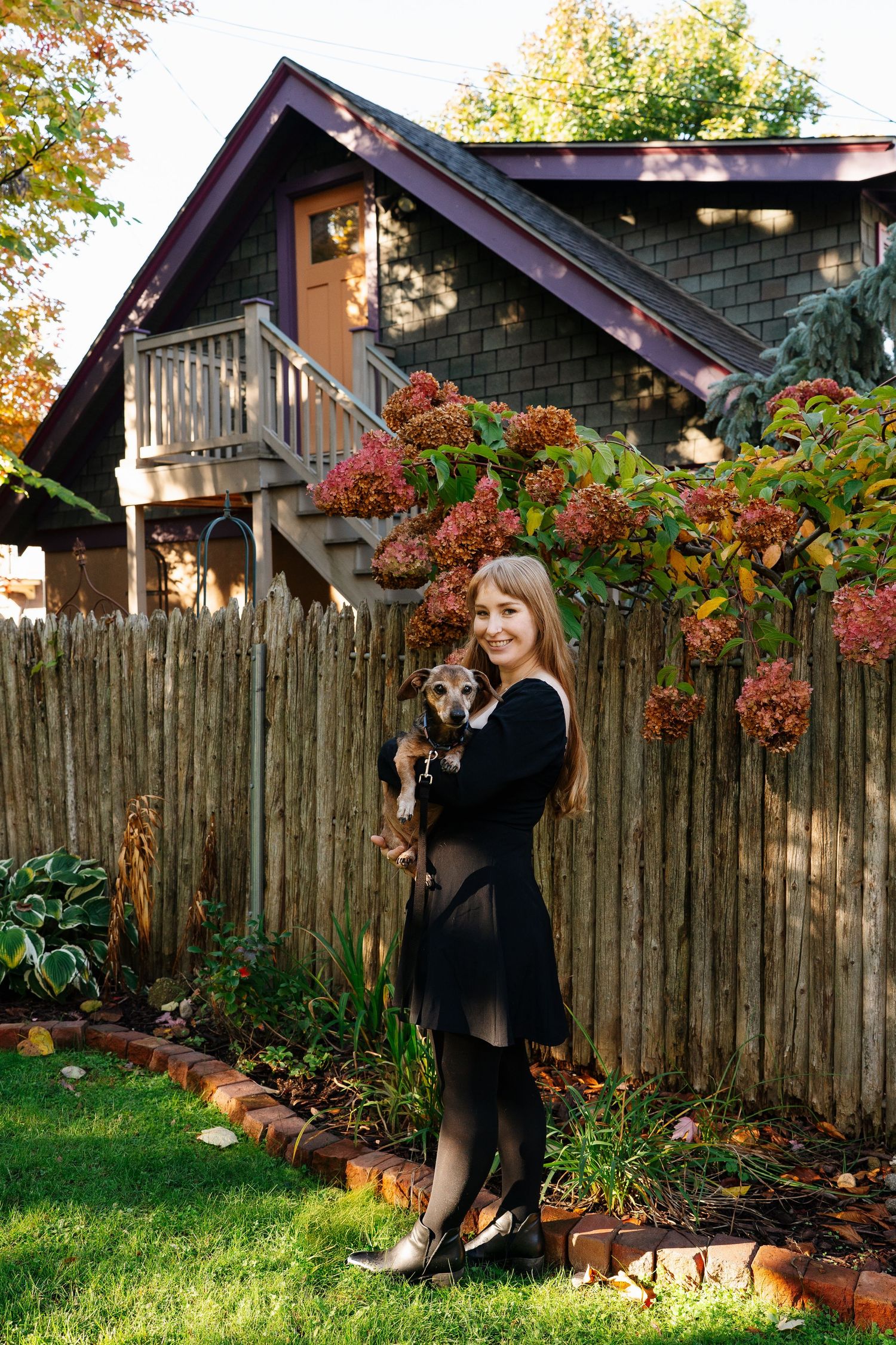Autumn garden scene with wooden fence and colorful fall foliage.
