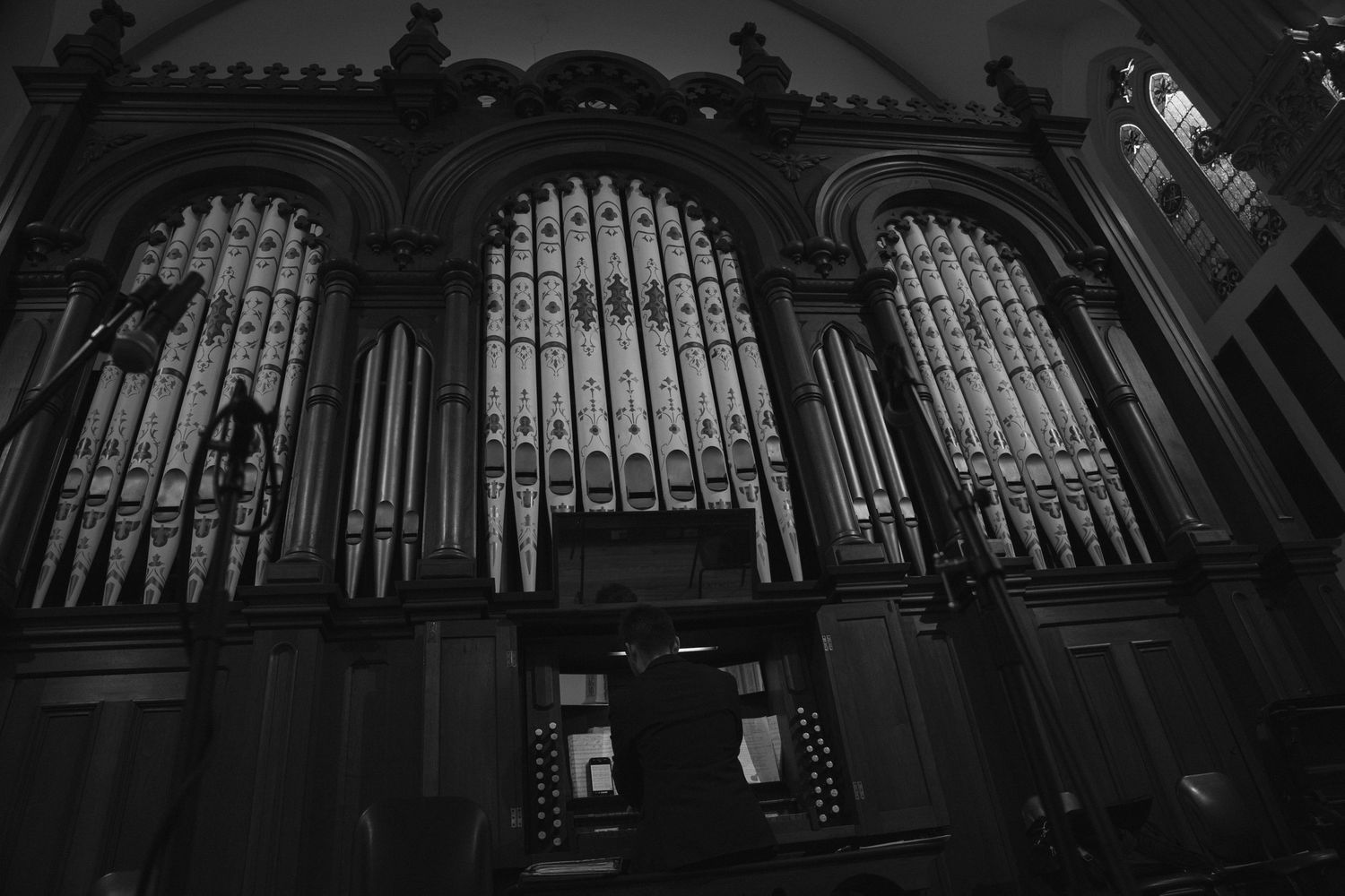 A dramatic black and white photograph of church organ pipes.