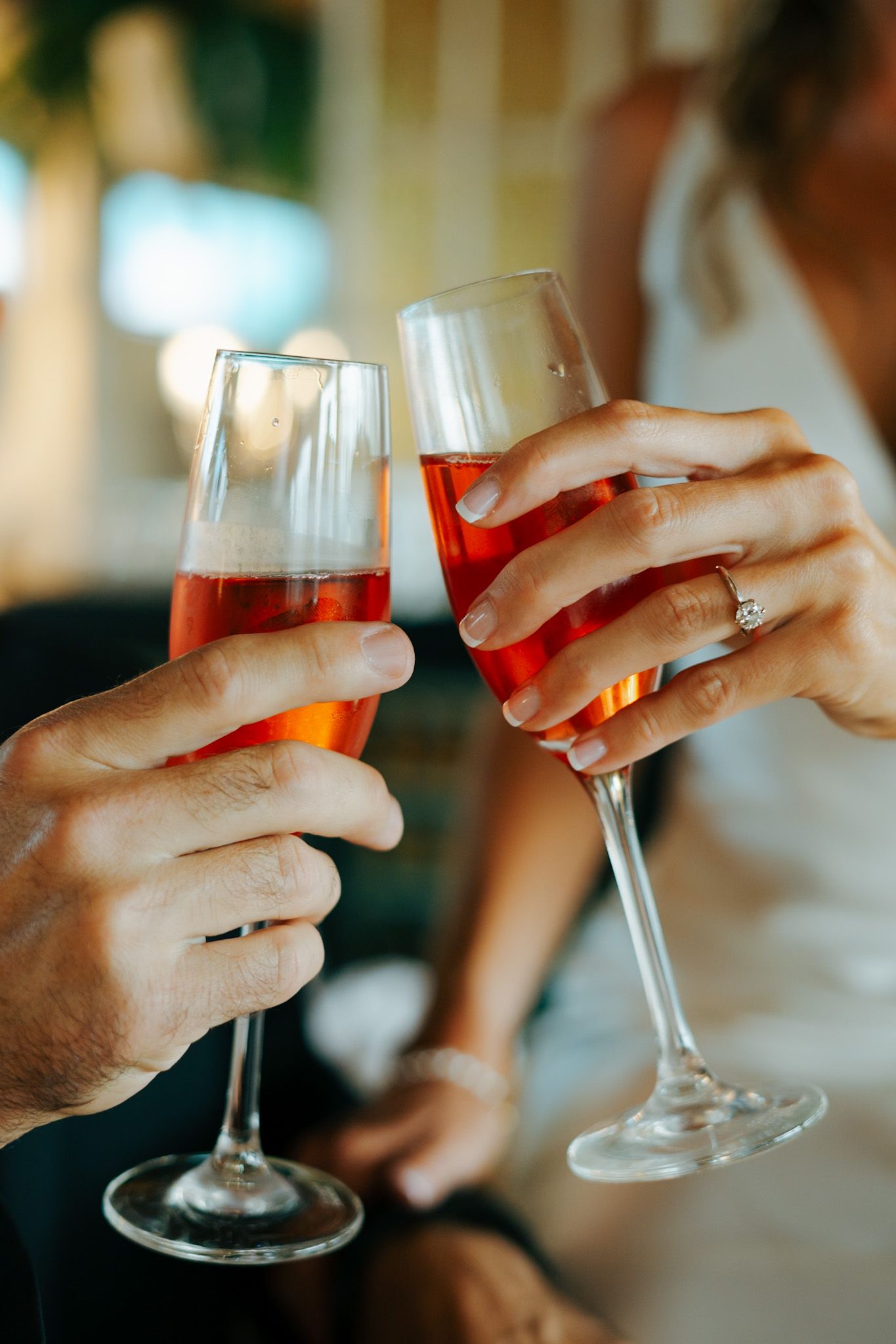Close-up of hands toasting with wine glasses at a celebration.