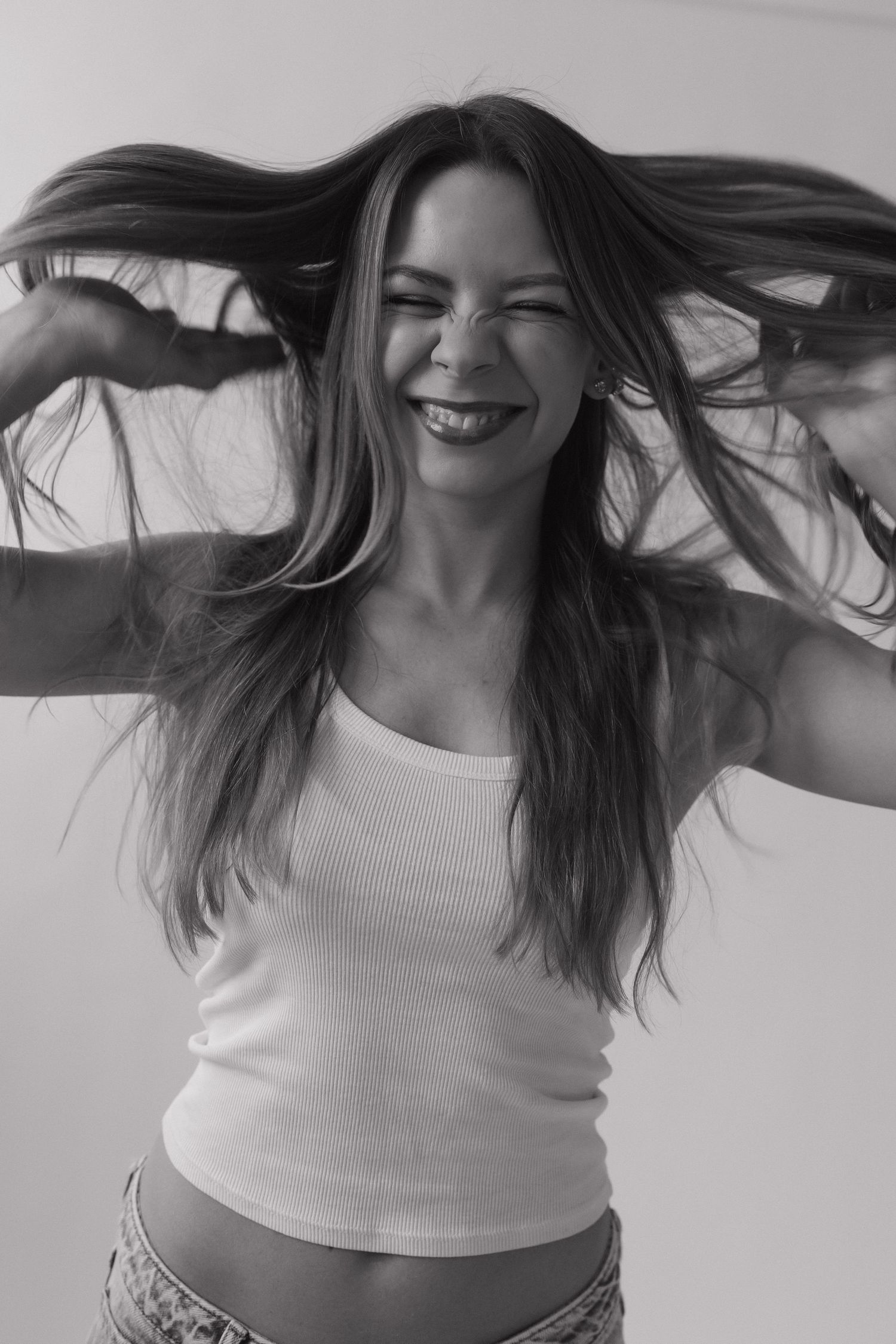 A series of black and white photos showing someone in a white top with flowing hair in motion.
