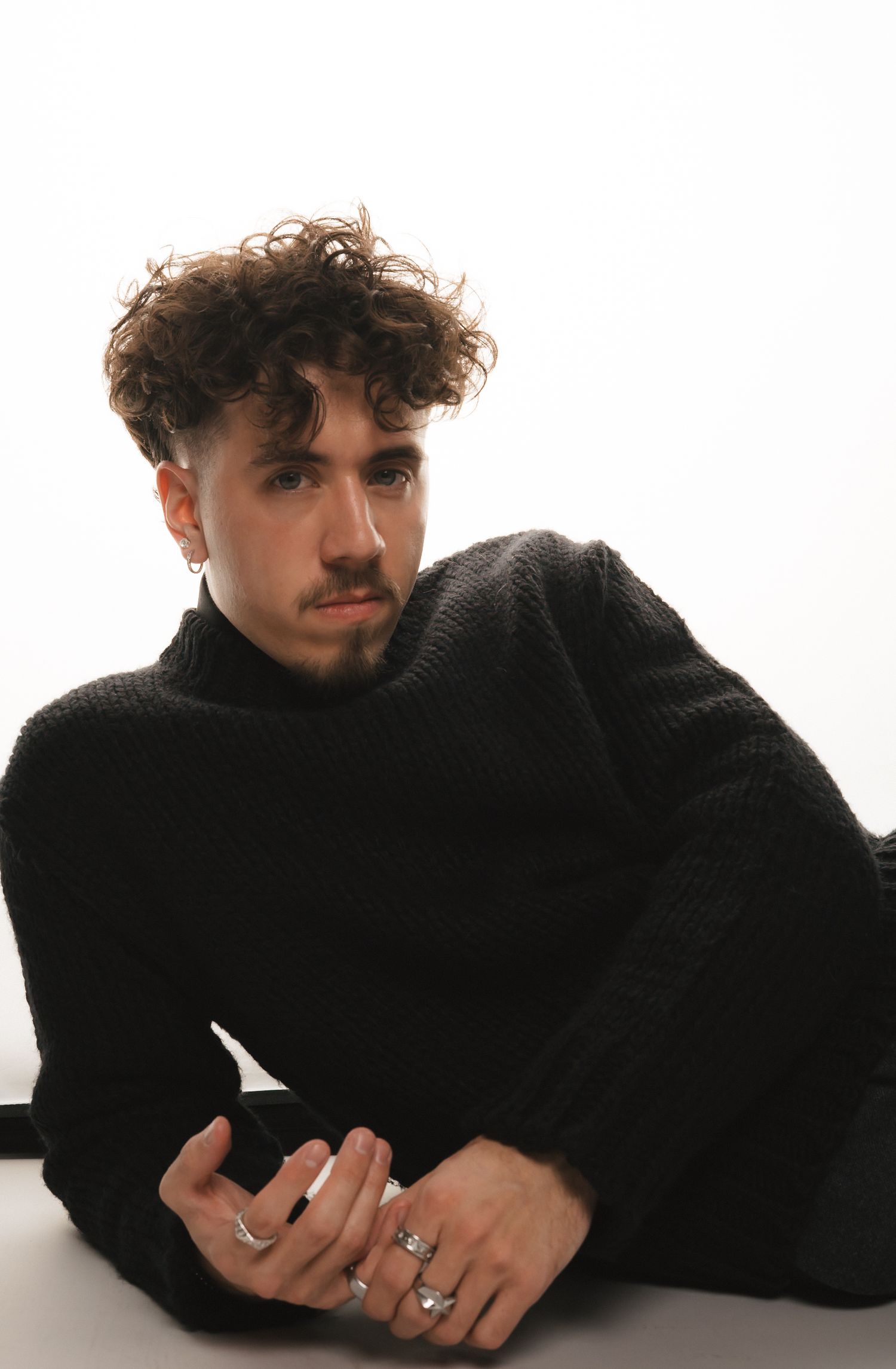 Artistic portrait series featuring model in black sweater against white background.