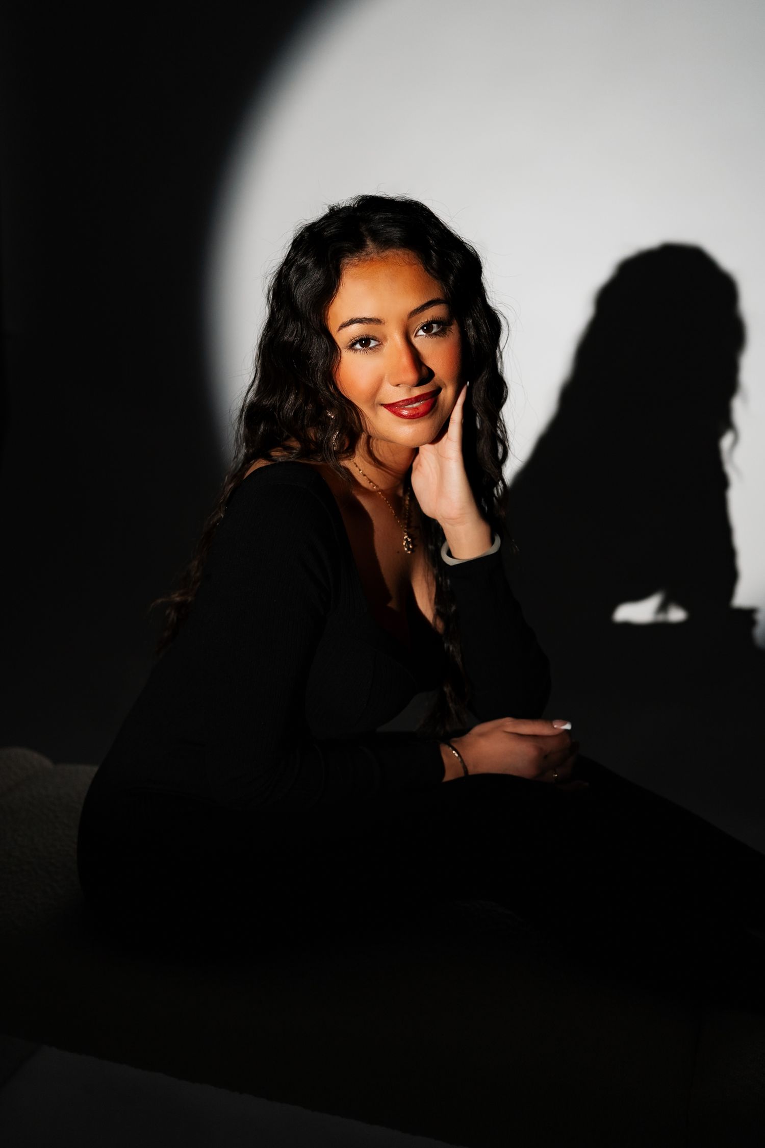 Elegant portrait with dramatic side lighting creating strong shadow effects.