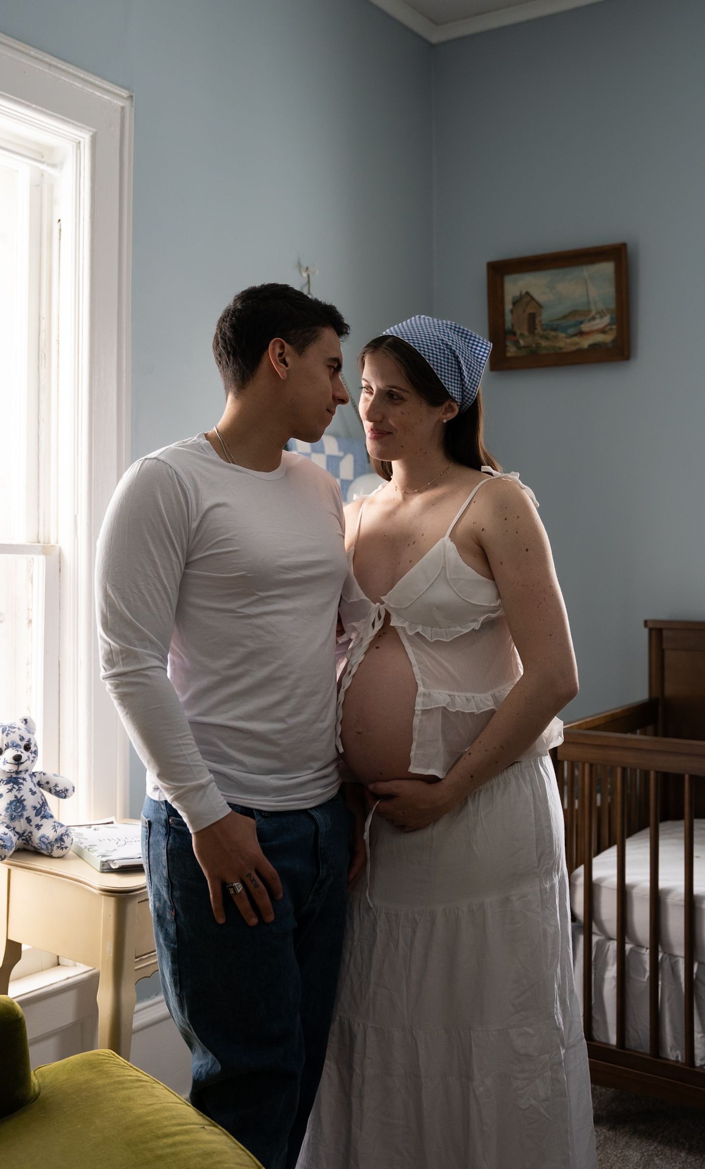 Intimate moment between couple in vintage-styled room with blue walls.