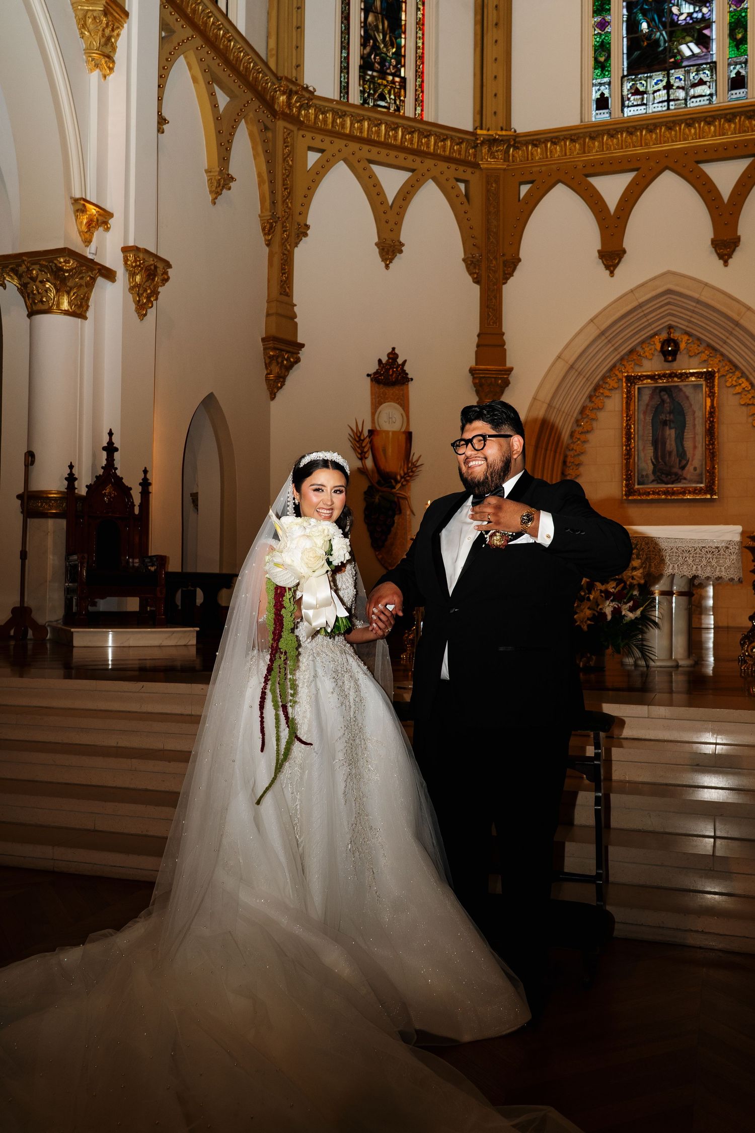 A couple shares intimate moments during their wedding in a beautiful church with Gothic architectural details.