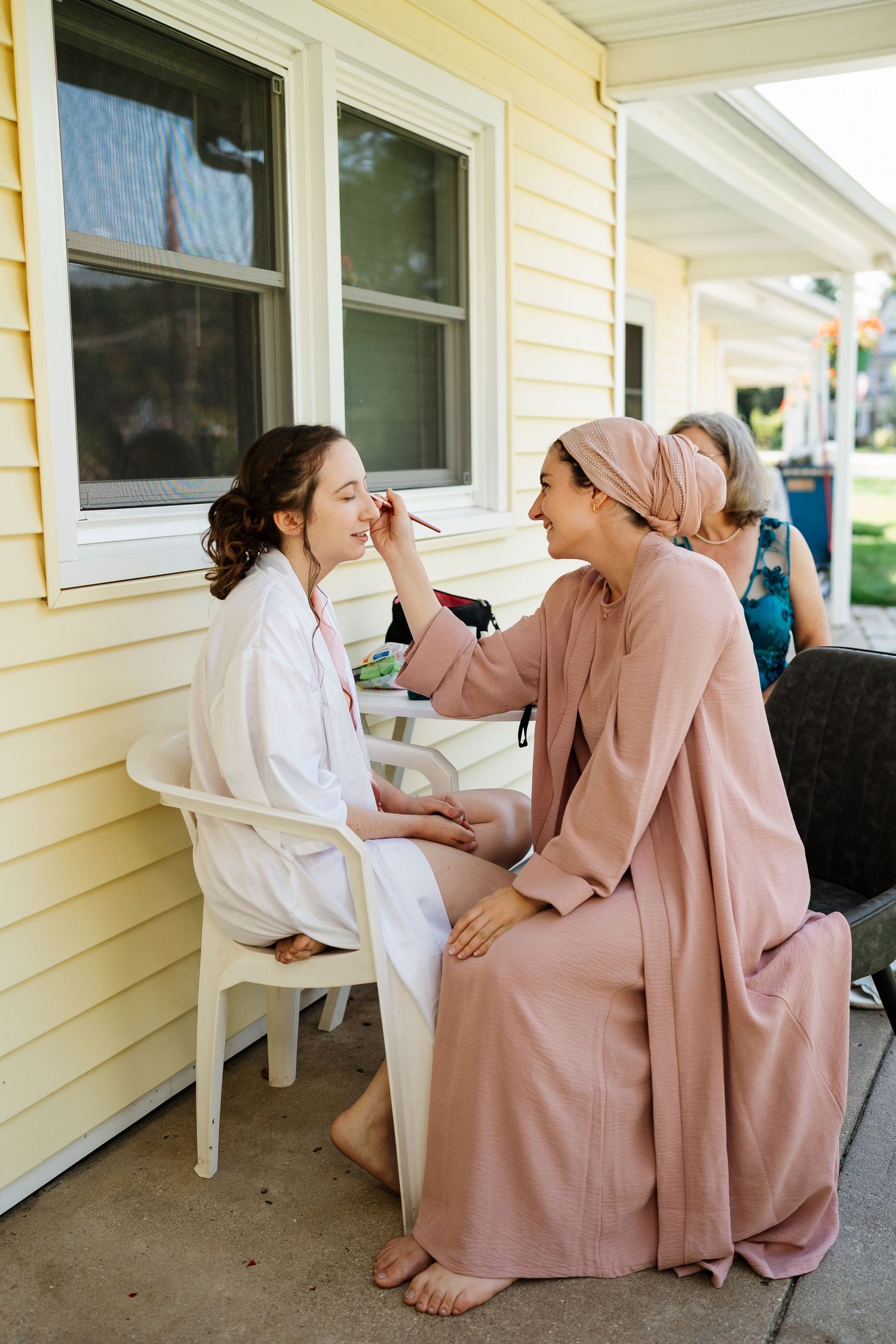 Relaxed conversation on front porch of yellow house.