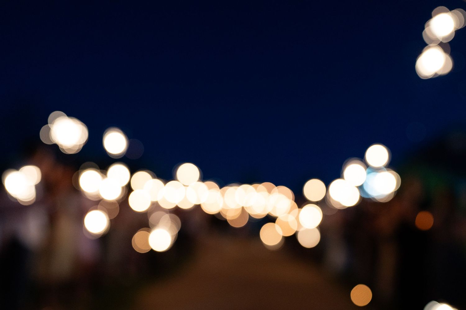 String lights create a romantic bokeh effect against a dark blue evening sky.