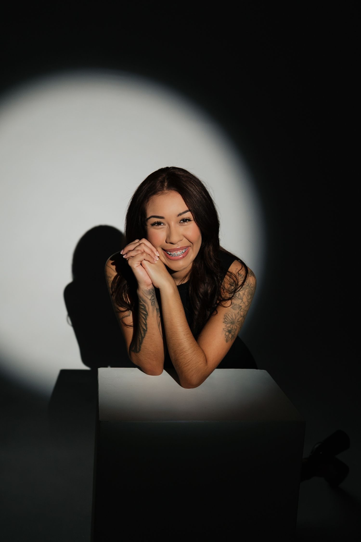 Creative portrait with dramatic spotlight creating contrast between light and shadow.