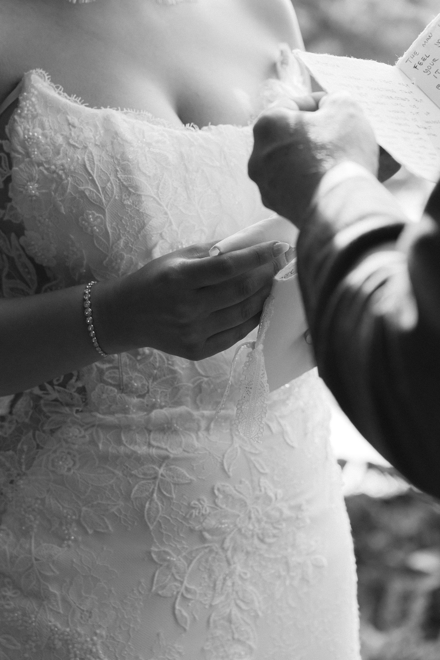 Close-up detail of intricate white lace pattern on a wedding dress.