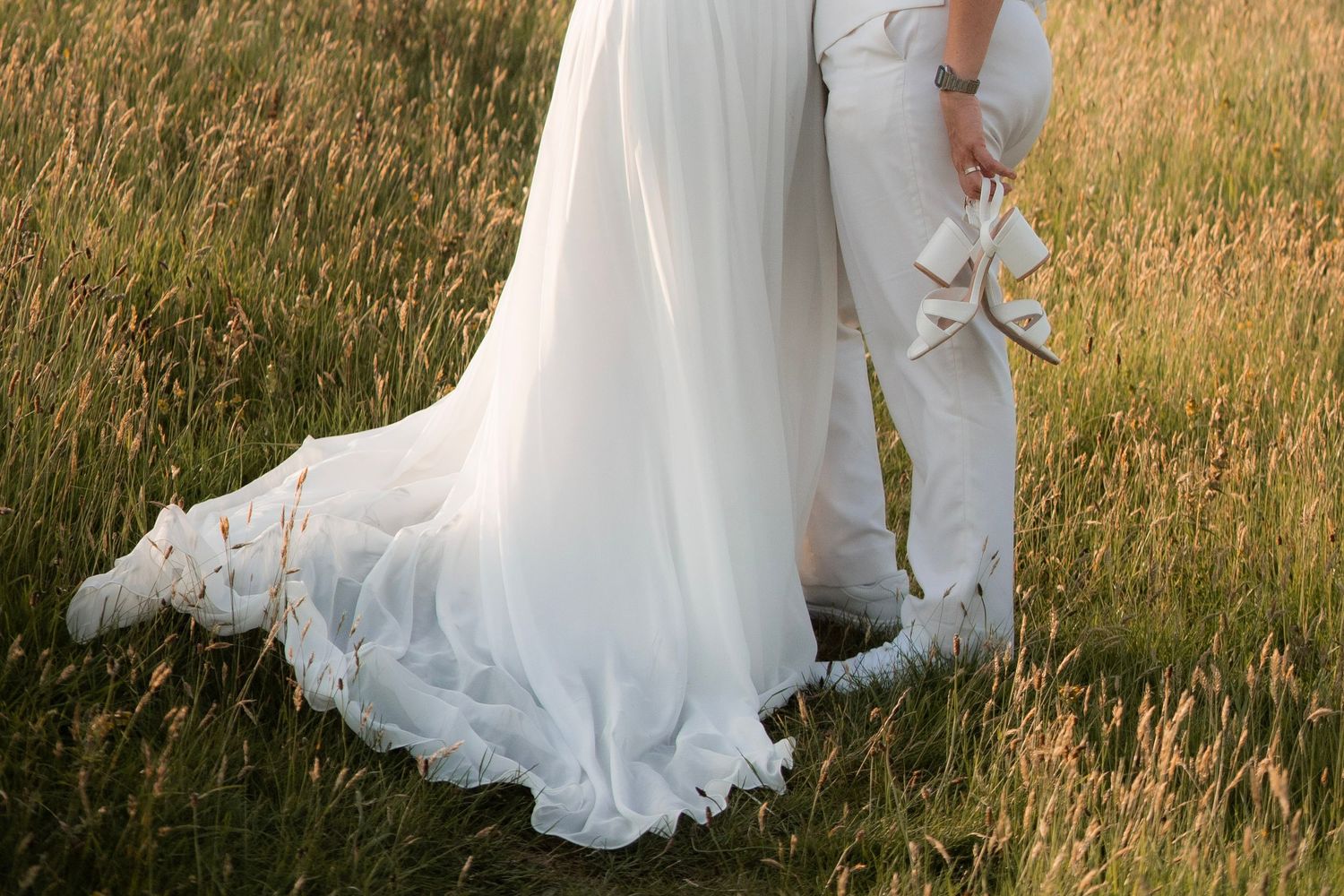 Bride and bride hugging, dress from Wed2B and suit from King and Allen
