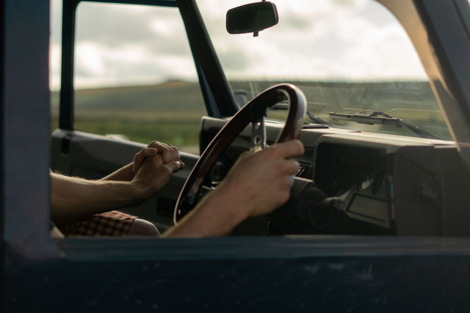 Couple holding hands in the front of their land rover during engagement photoshoot on Dartmoor National Park, Devon