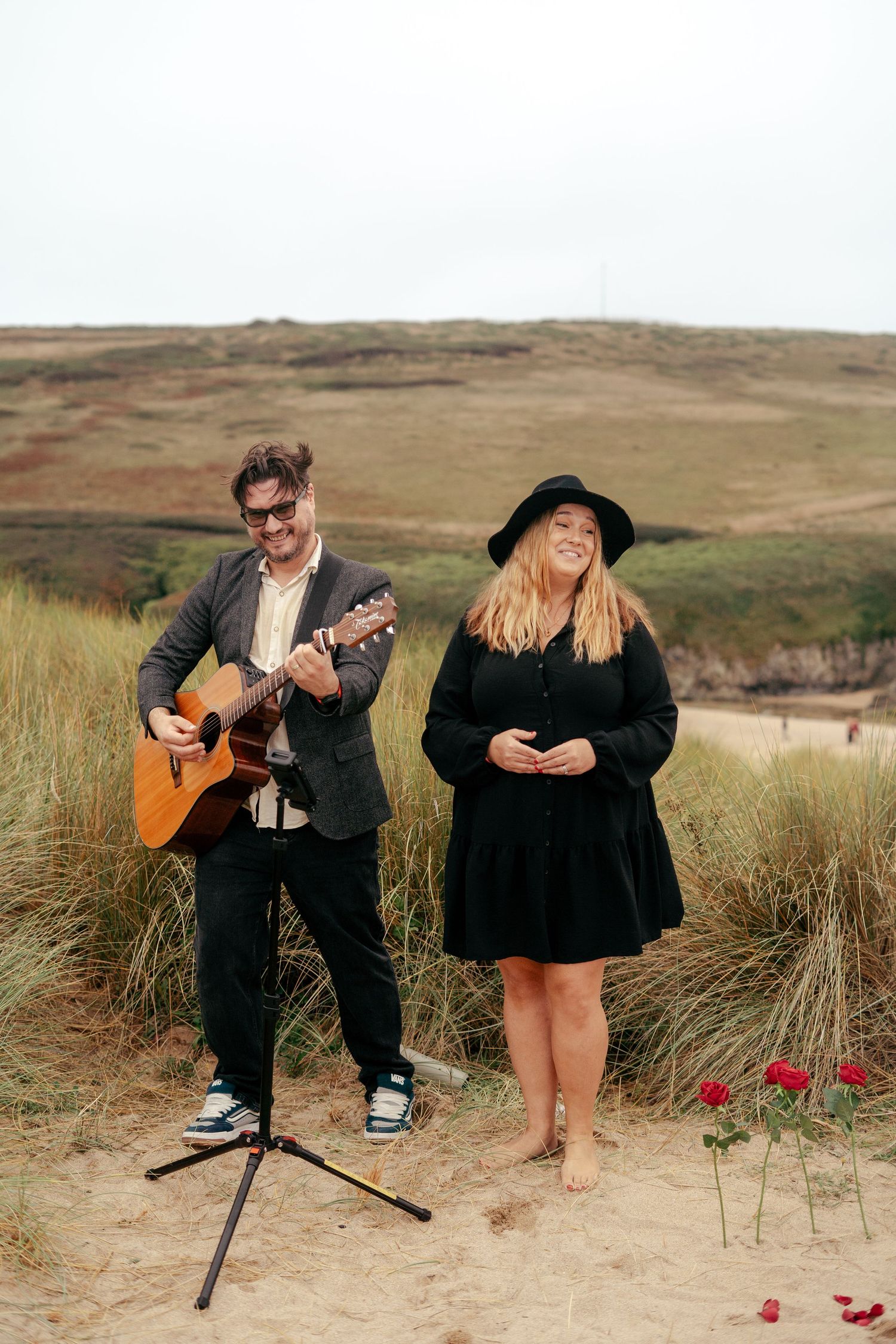 Live vocalist and guitar player on the beach in Cornwall, playing during a proposal in the dunes