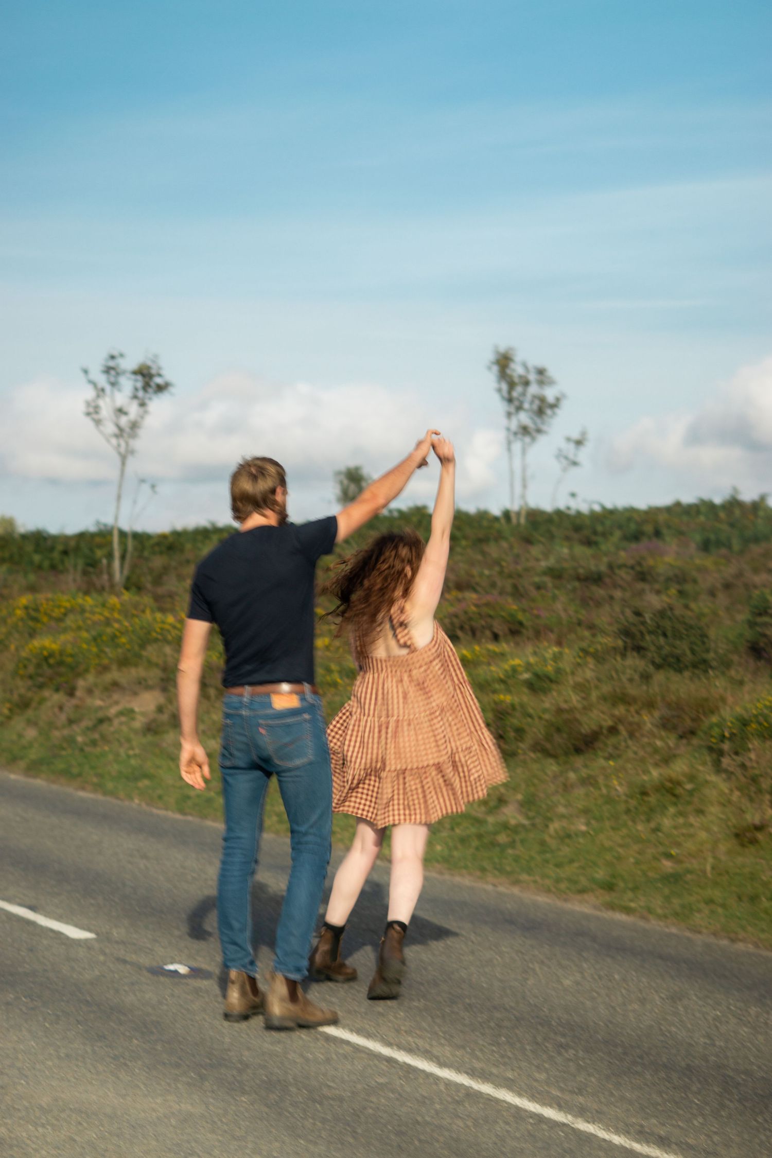 Photo of a man twirling his girlfriend during an engagement photoshoot on Dartmoor National Park, Devon