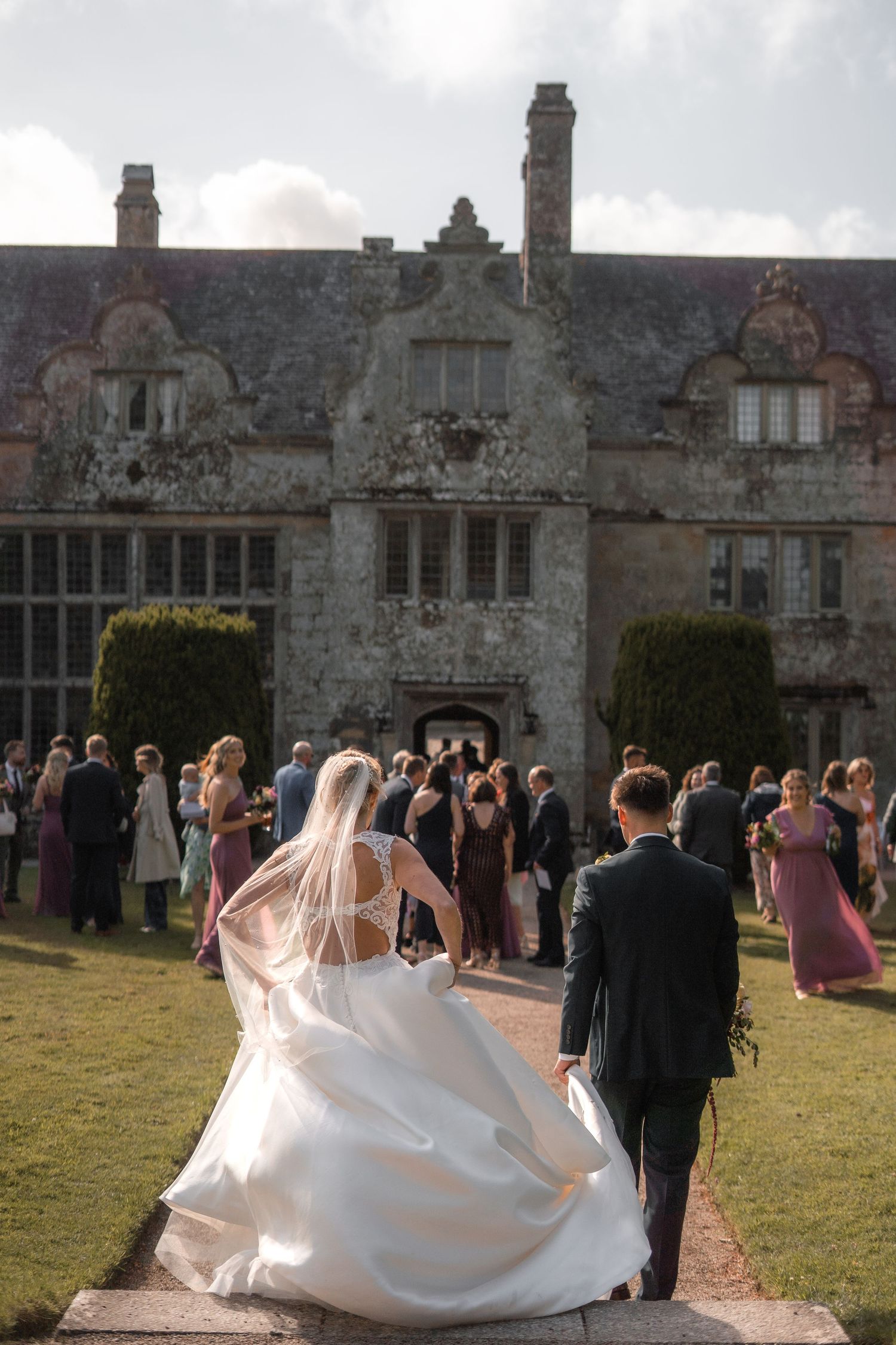 Trerice National Trust wedding, with bride and groom rejoining their wedding party after couples portrait