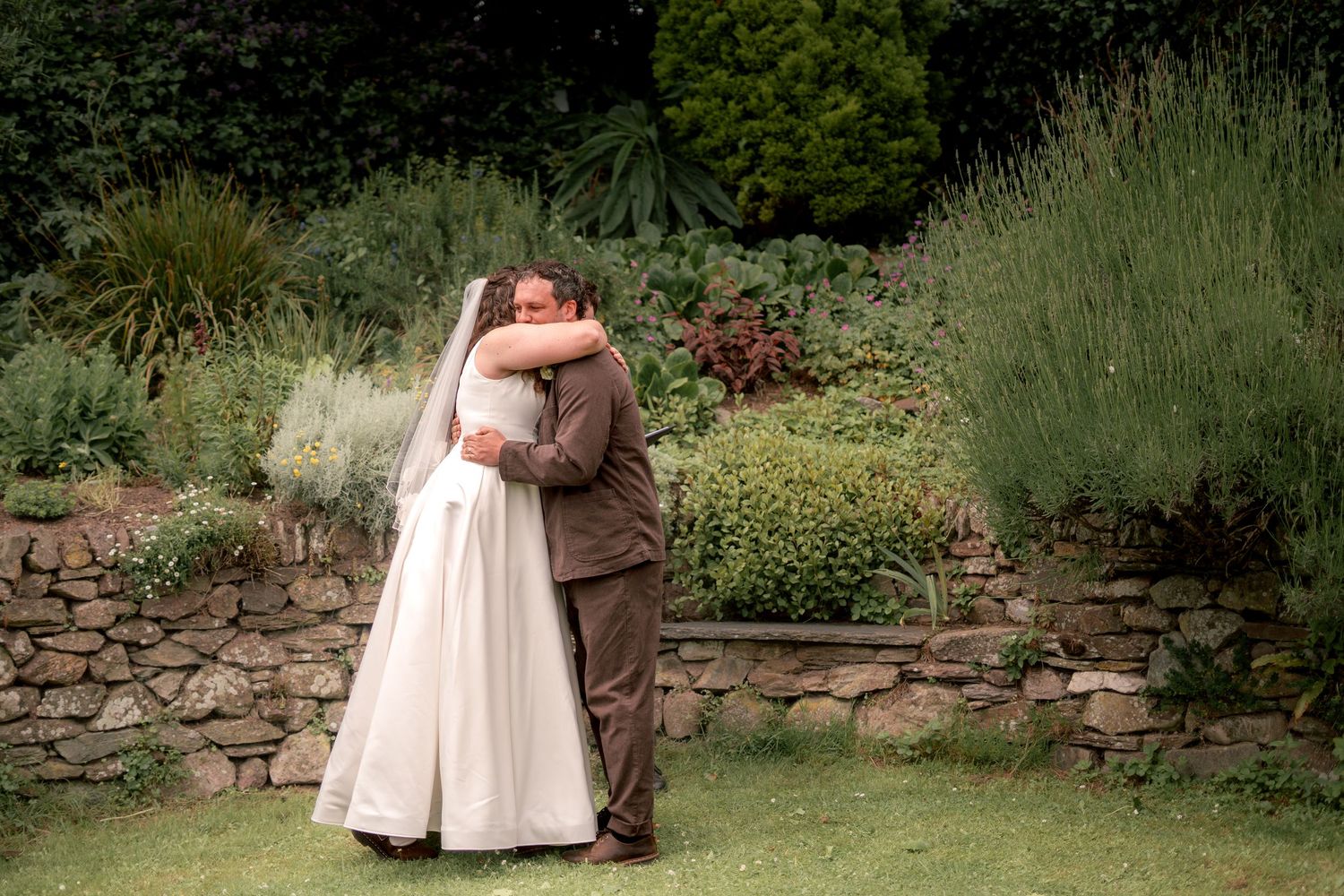 Bride and groom sharing a moment after their garden ceremony in Cornwall
