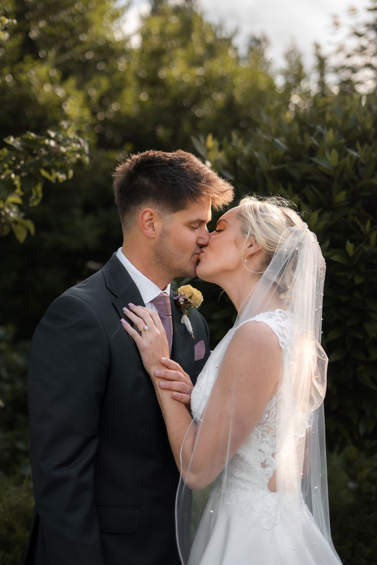 Bride & groom kissing in the grounds of Trerice National Trust, captured by a Cornwall wedding photographer