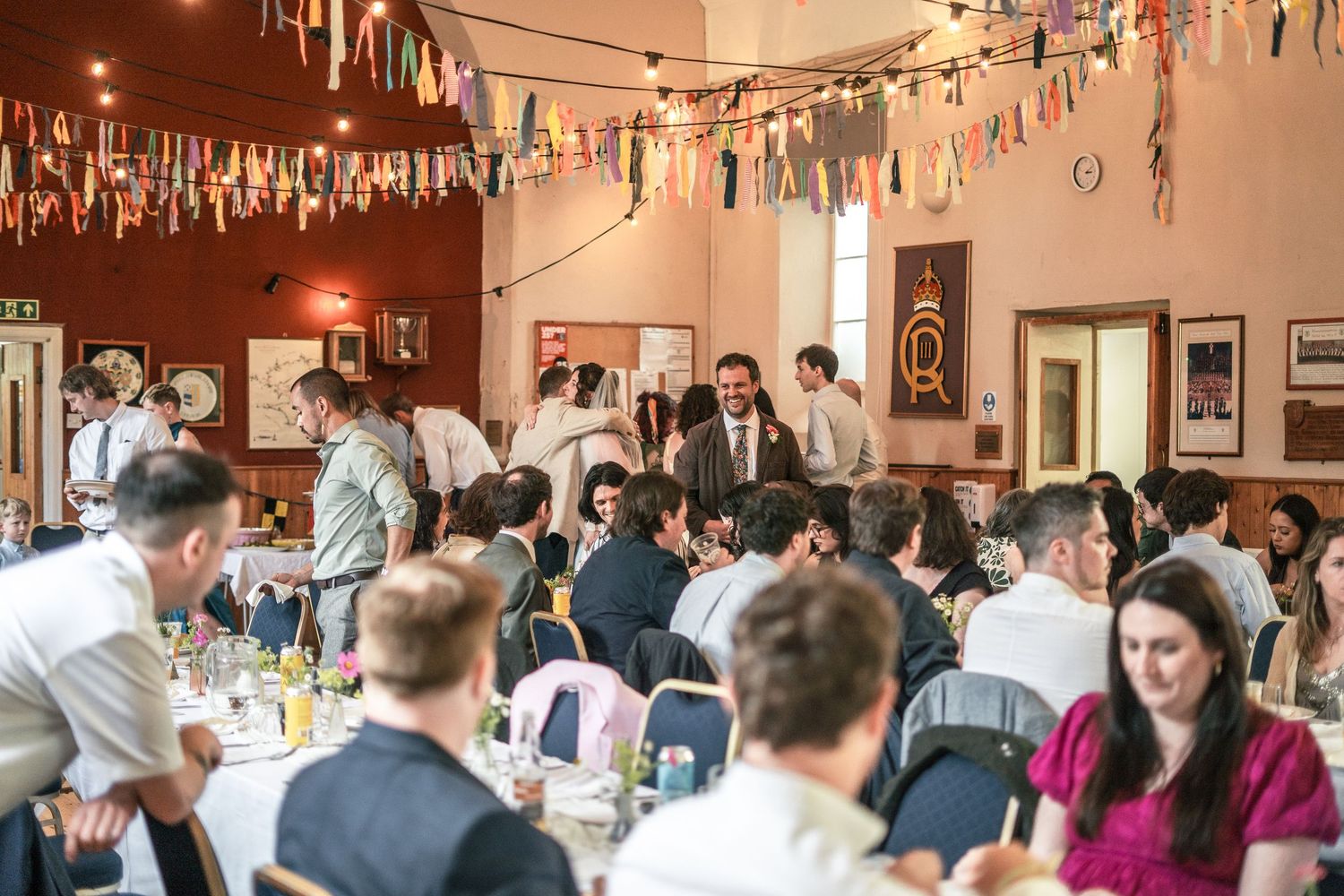 Village hall filled with wedding guests enjoying the wedding breakfast