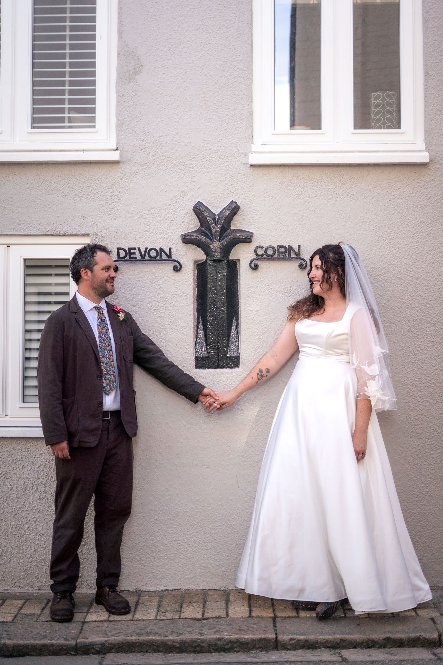 Bride and groom posing with the Devon/Cornwall border sign