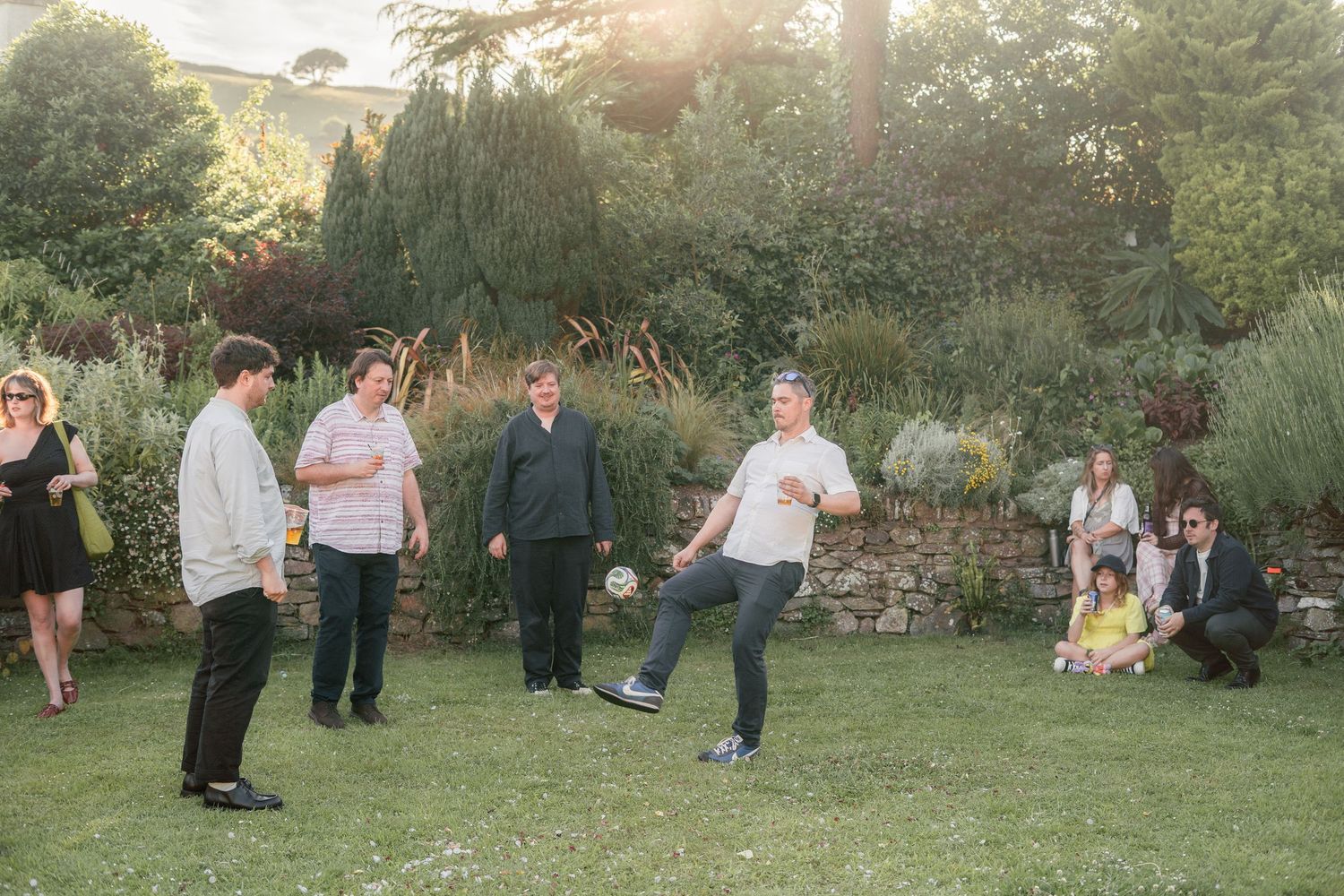 Wedding guests playing football in the garden
