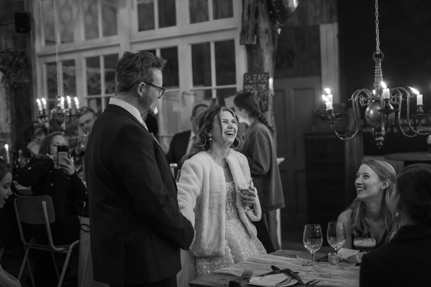 Bride and groom candidly laughing at their wedding reception in Penzance, Cornwall