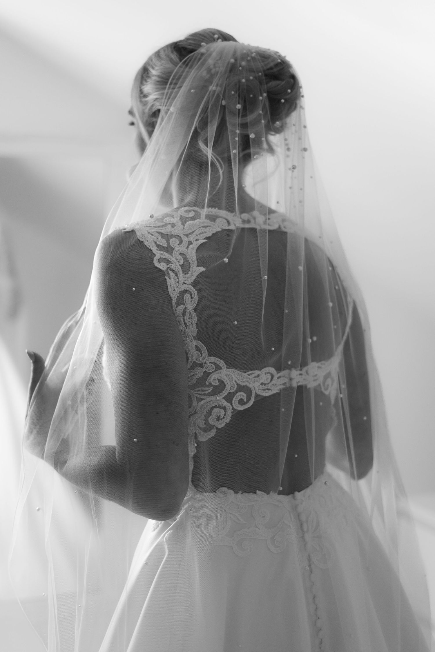 Bride wearing her wedding dress from Bliss Bridal Gowns, with beaded back details. Beautiful veil with pearl detailing.