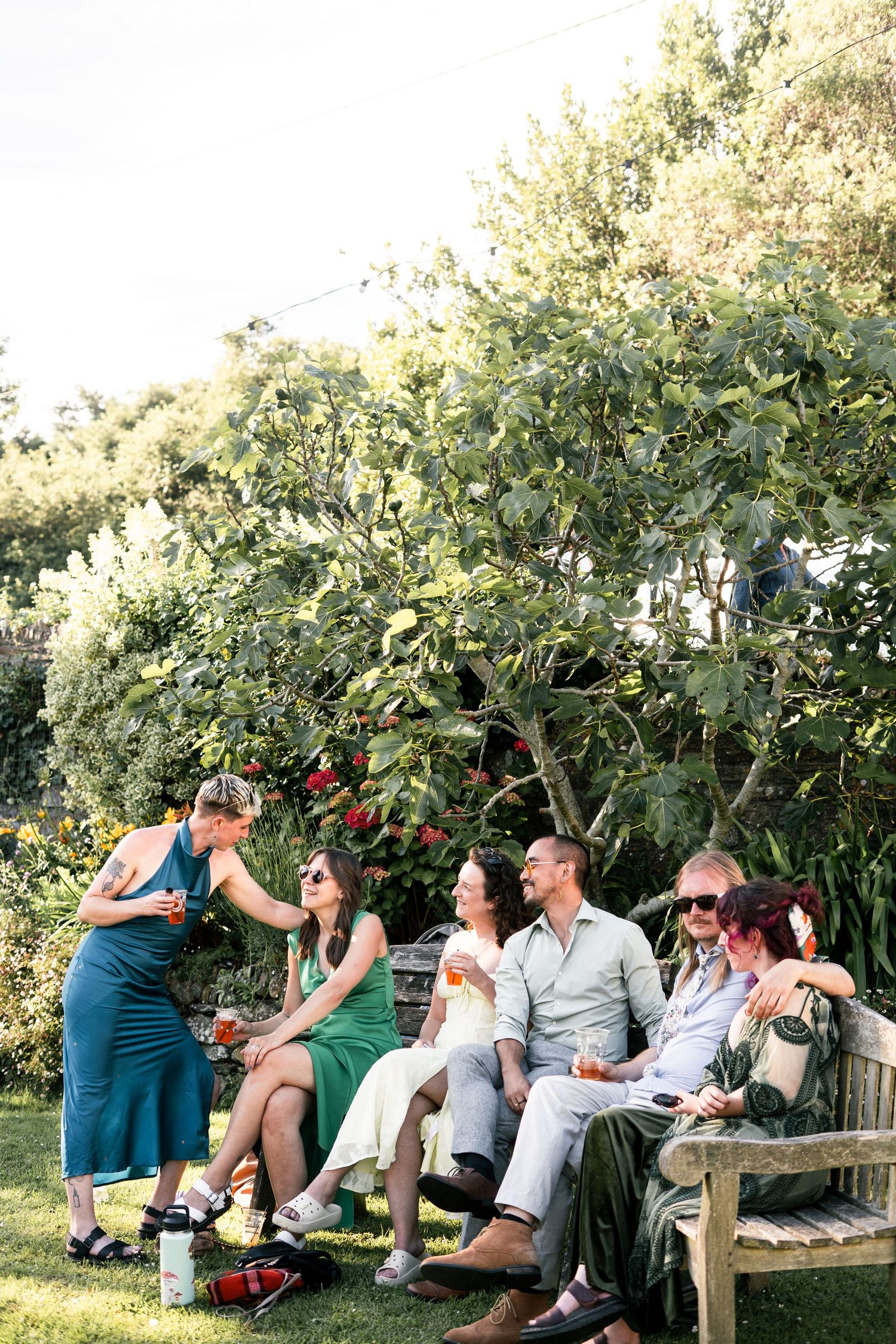 Candid image of wedding guests enjoying the sun at a garden wedding in Devon