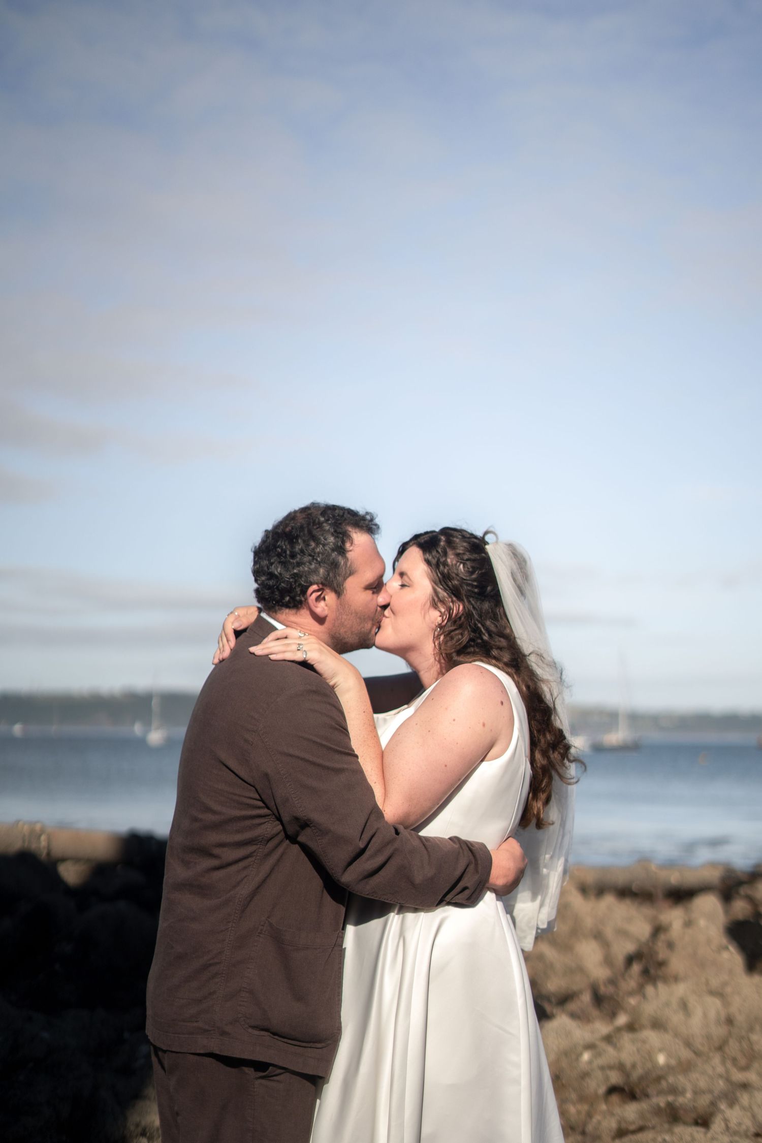 Bride and groom kissing on the beach during their wedding in Cornwall