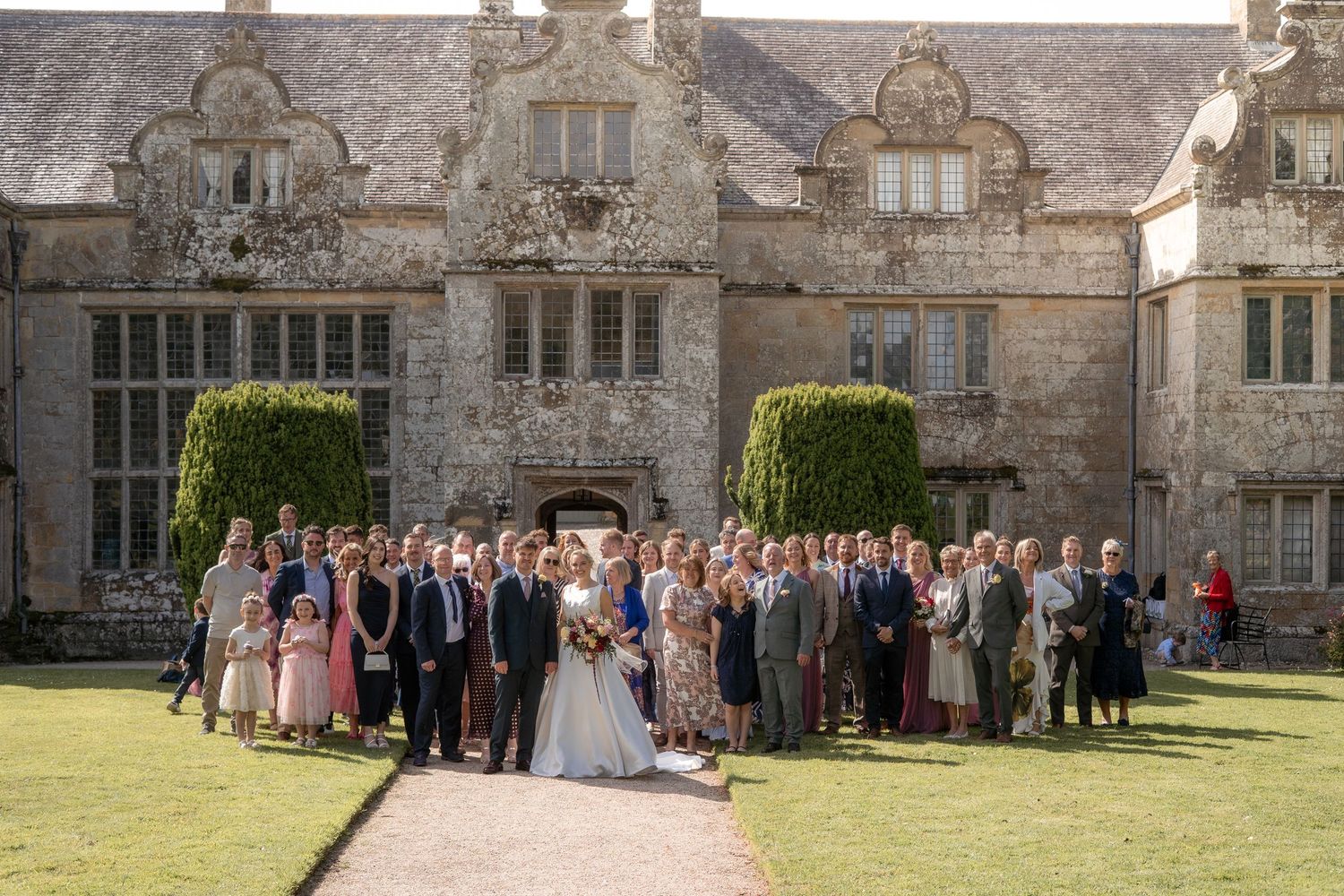Photo of entire wedding party outside Trerice National Trust, photographed by Cornwall wedding photographer