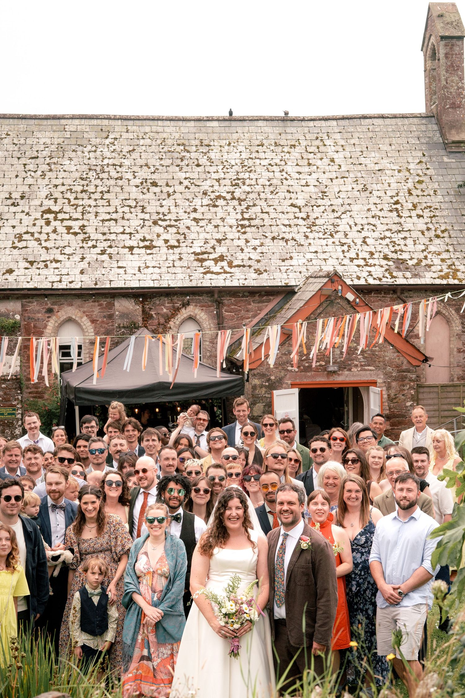 Photo of the bride and groom surrounded by all wedding guests