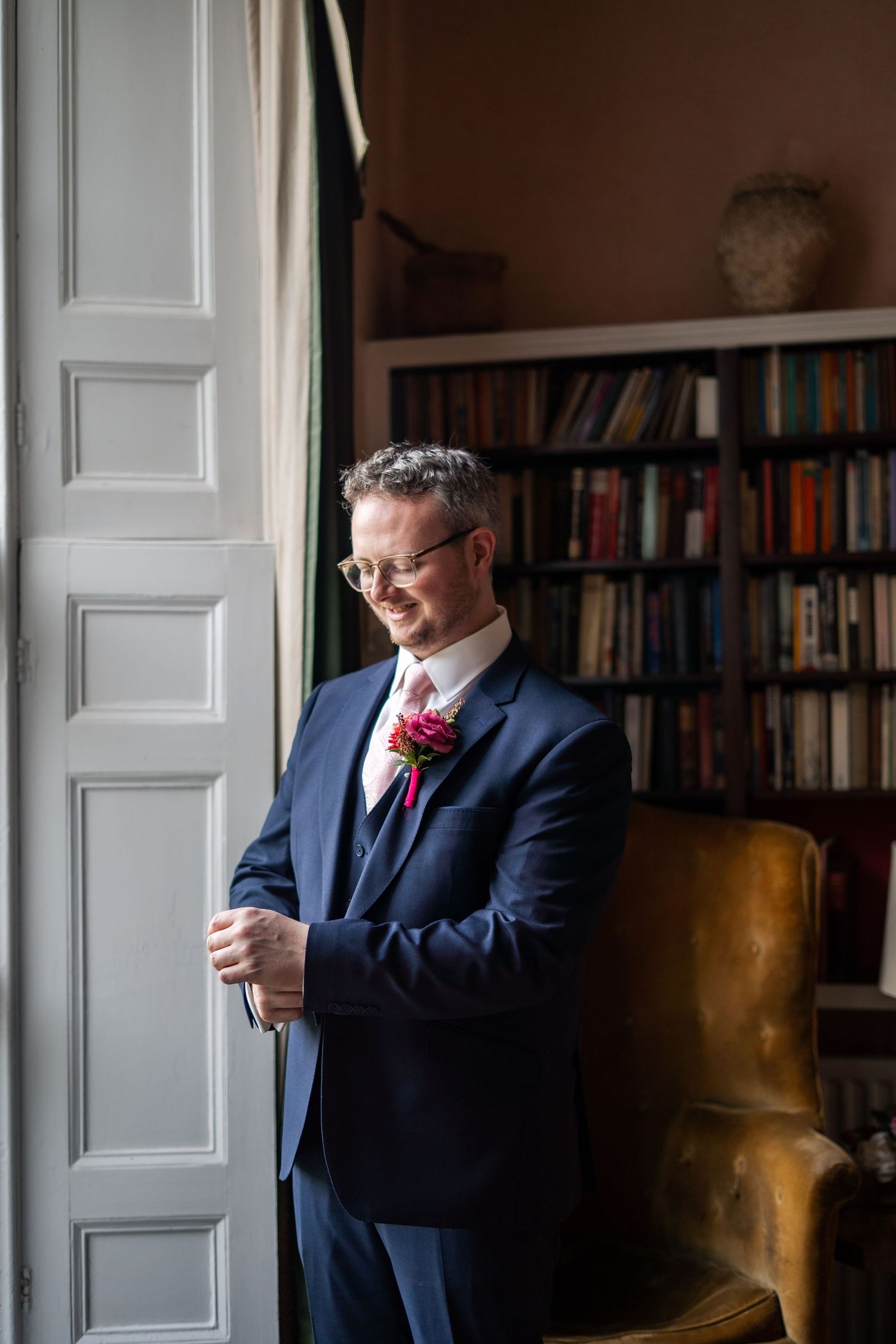 Editorial, candid photo of groom getting ready before a church wedding in Cornwall