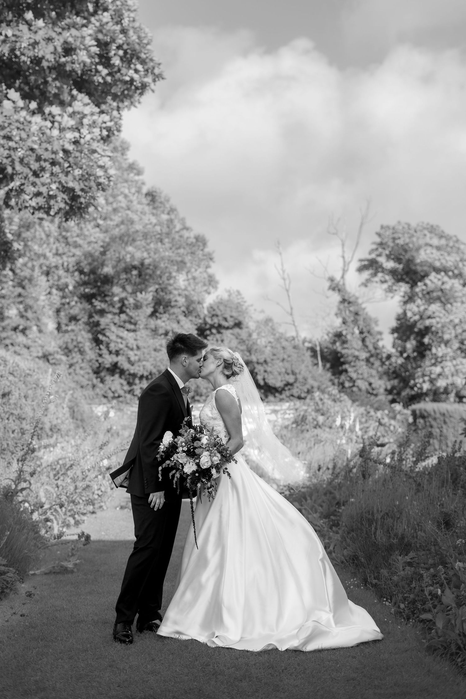 Black and white bride and groom portrait in the gardens of Trerice National Trust, captured by a Newquay wedding photographer