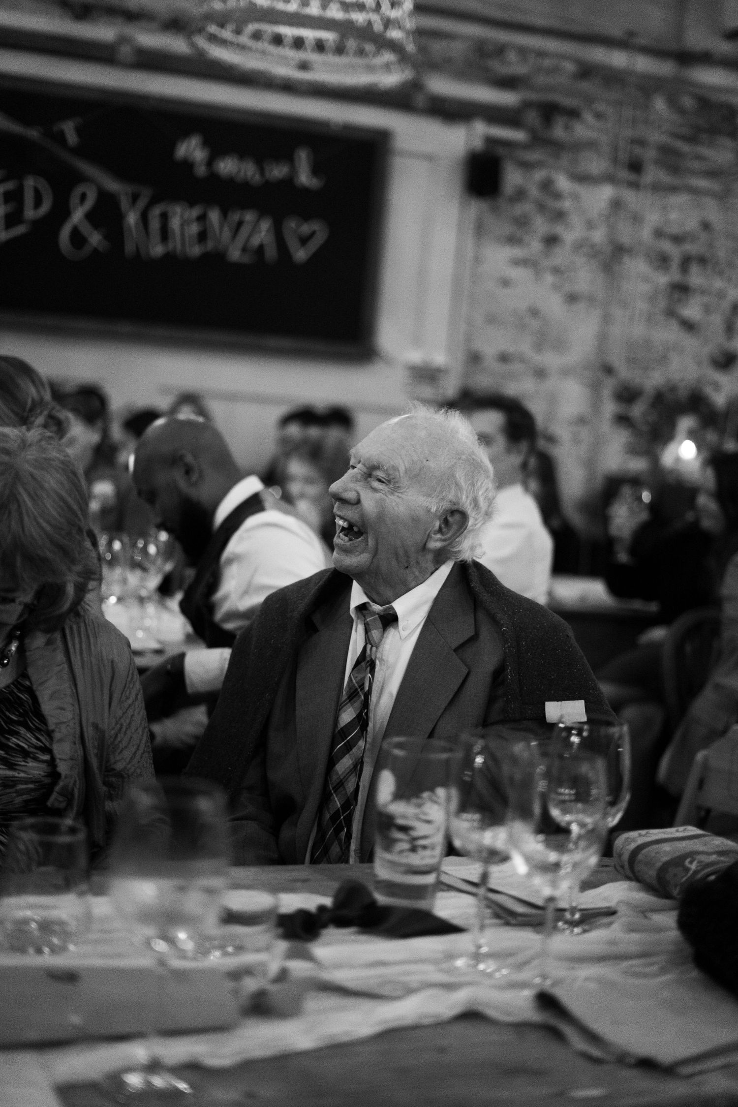 Candid photo of grandparents laughing during wedding reception in Penzance, Cornwall