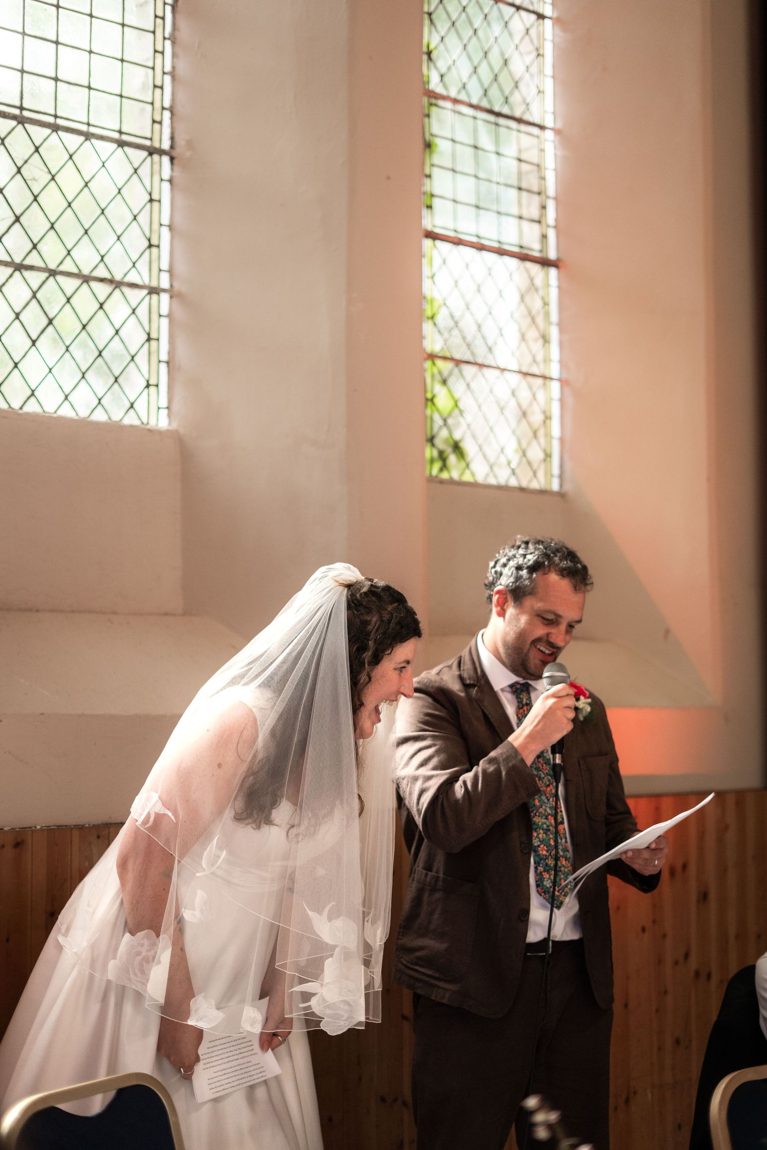 Bride and groom laughing during their speeches
