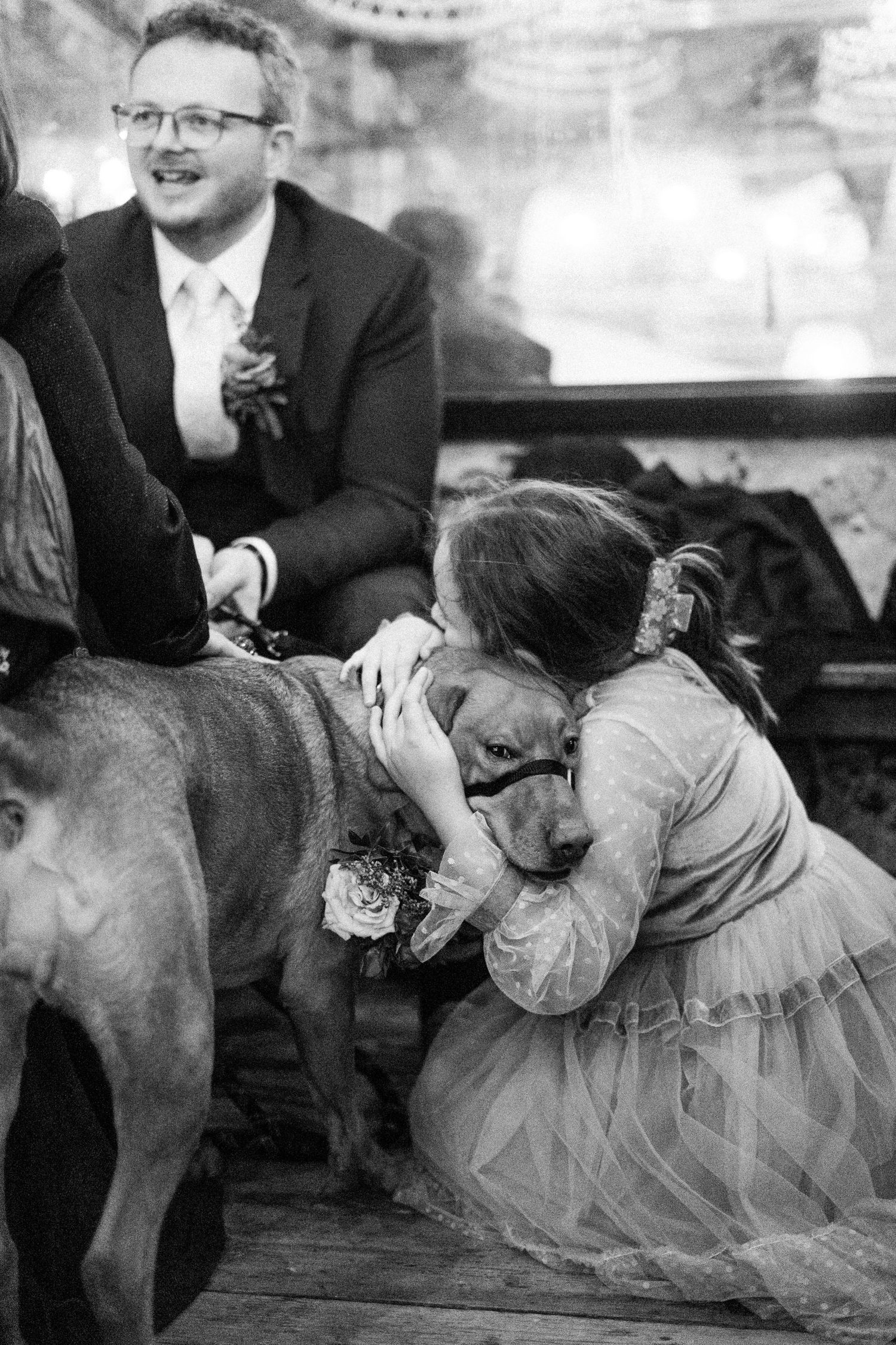 Candid photo of bride cuddling her dog at her wedding reception