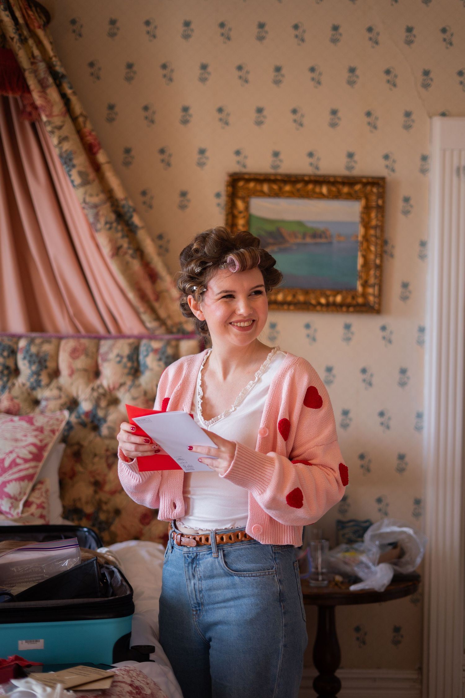 Candid photo of bride reading a card from her groom on their wedding morning in Cornwall