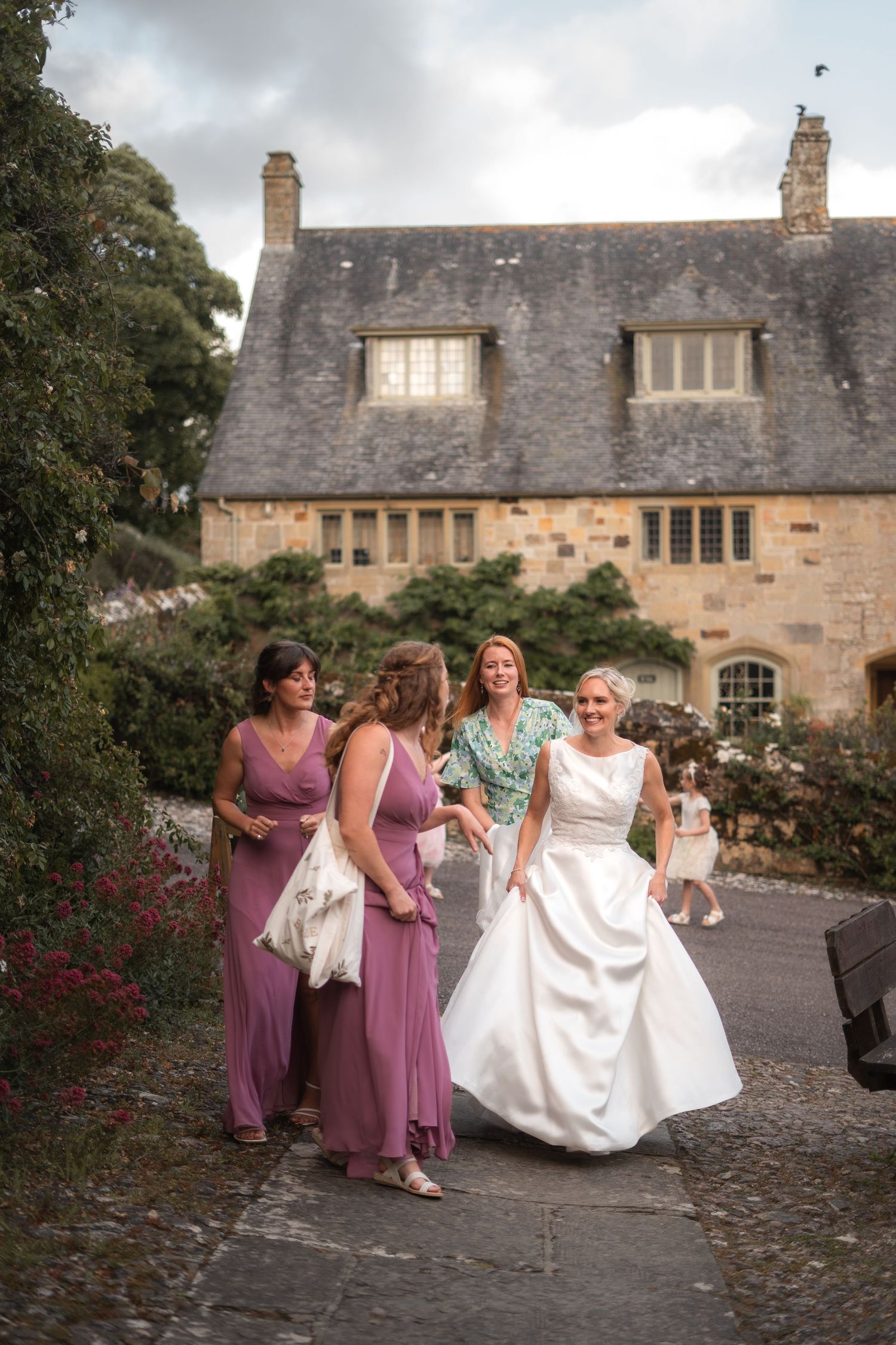 Bride arriving to the venue in her dress from Bliss Bridal Gowns, surrounded by her bridesmaids