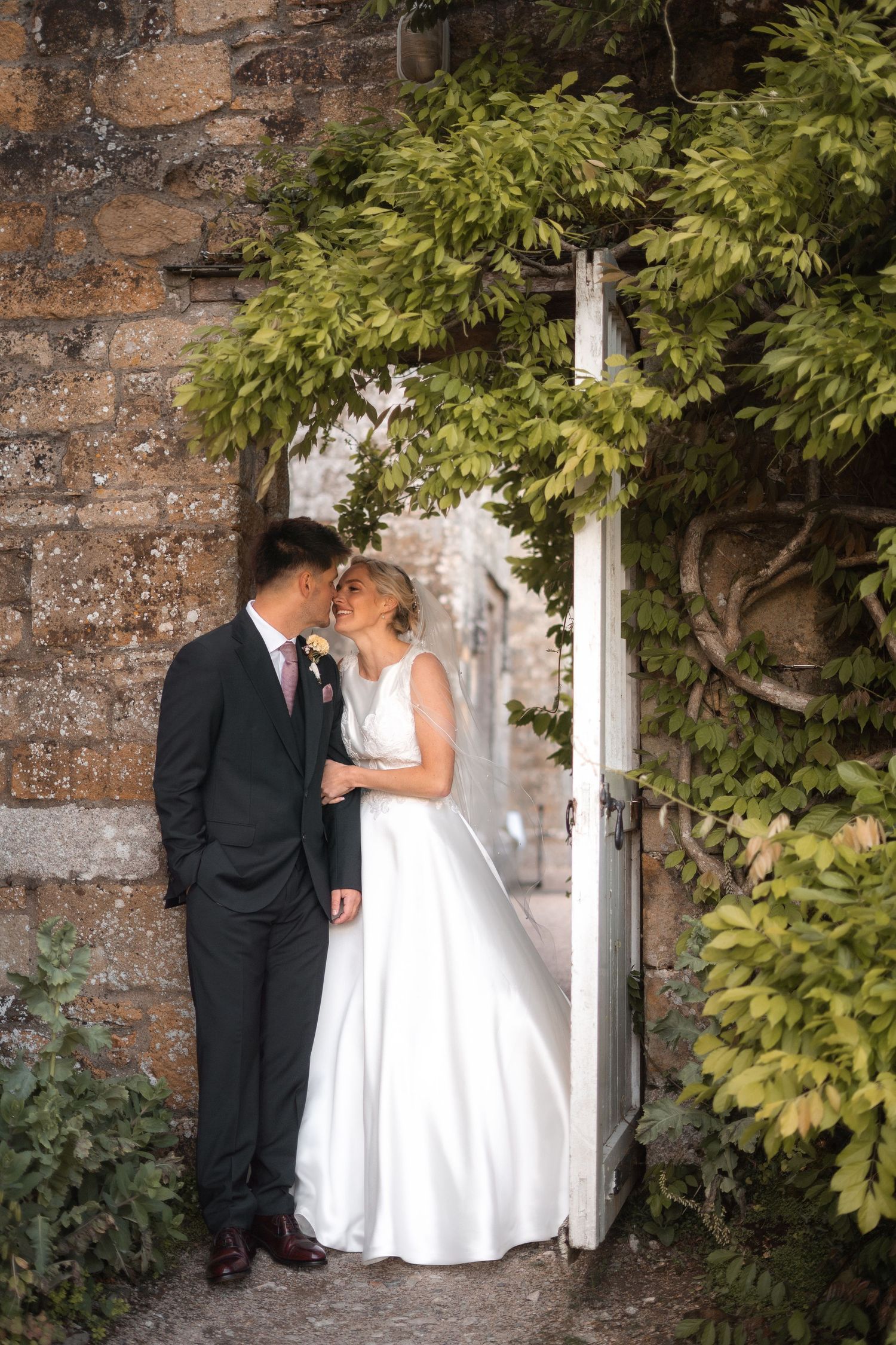 Bride and groom exploring the gardens of Trerice National Trust, captured by Newquay wedding photographer