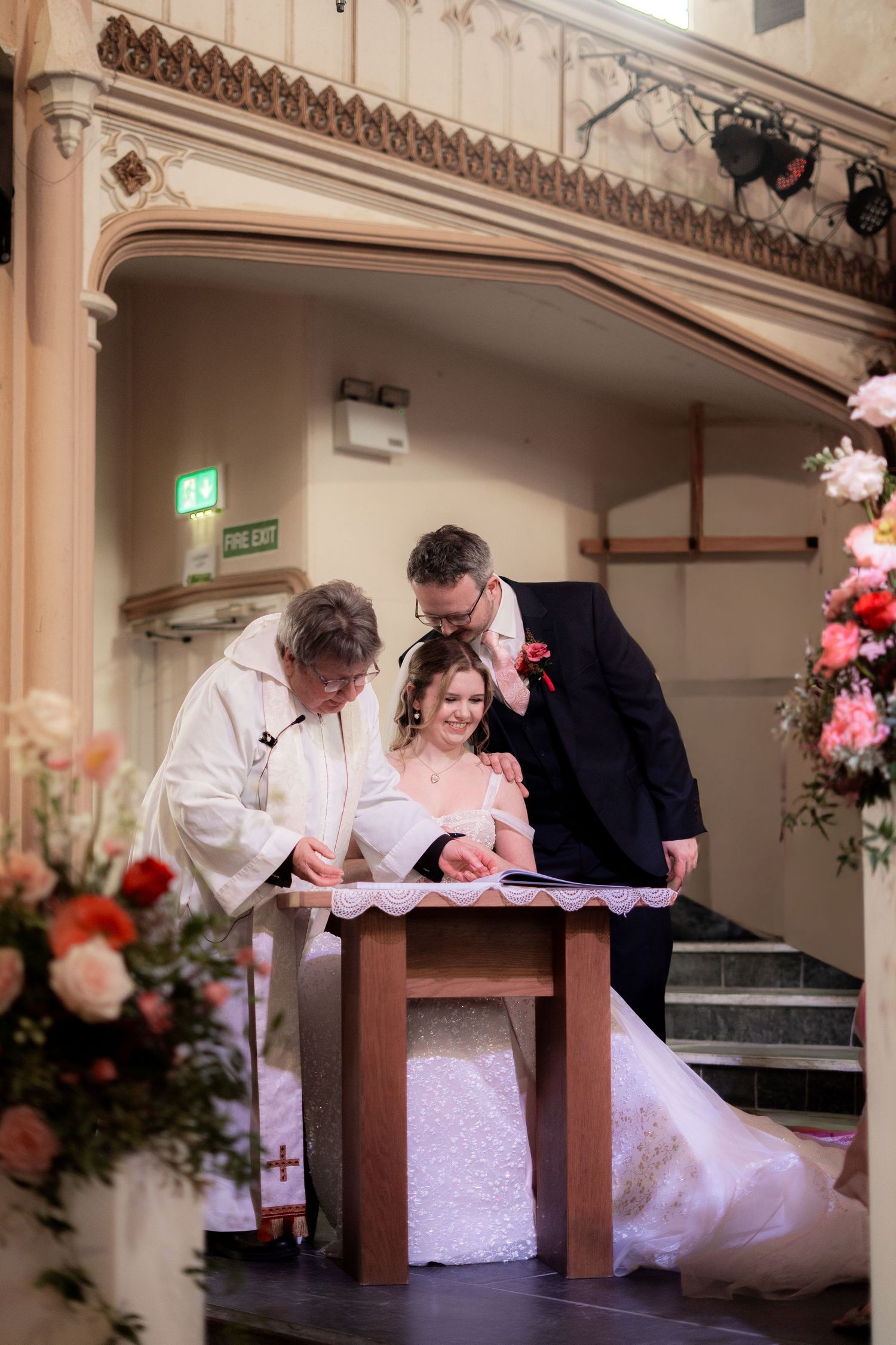 Bride and groom signing marriage documents inside Penzance Church, Cornwall