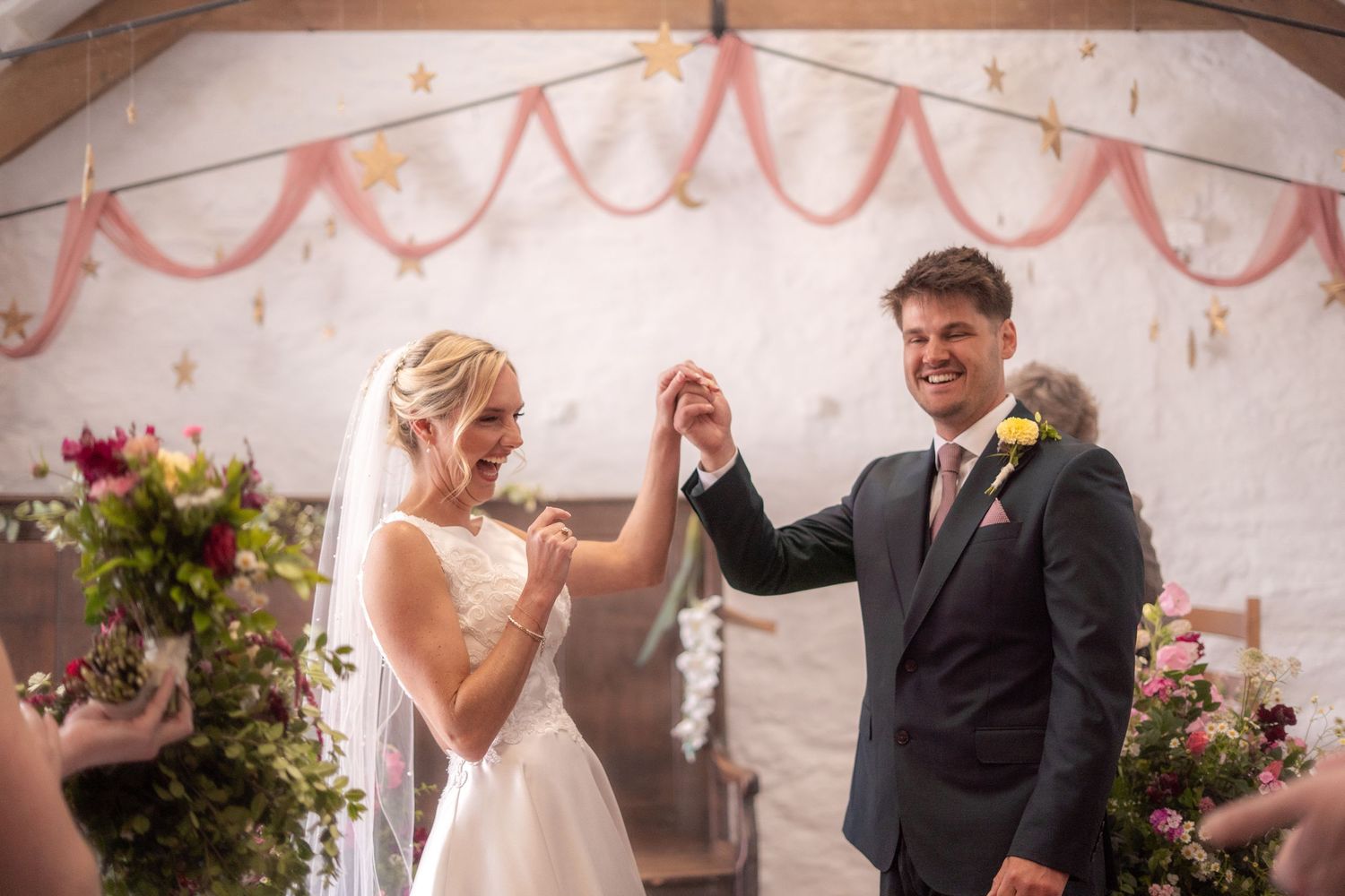 Candid photo of bride and groom celebrating after their ceremony at Trerice National Trust