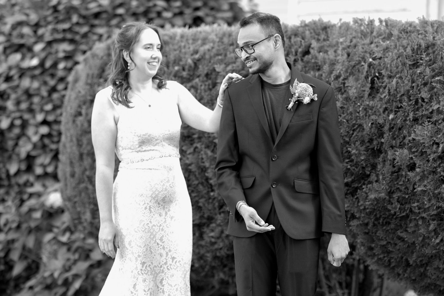 A couple shares joyful moments together in a garden setting during their wedding celebration.