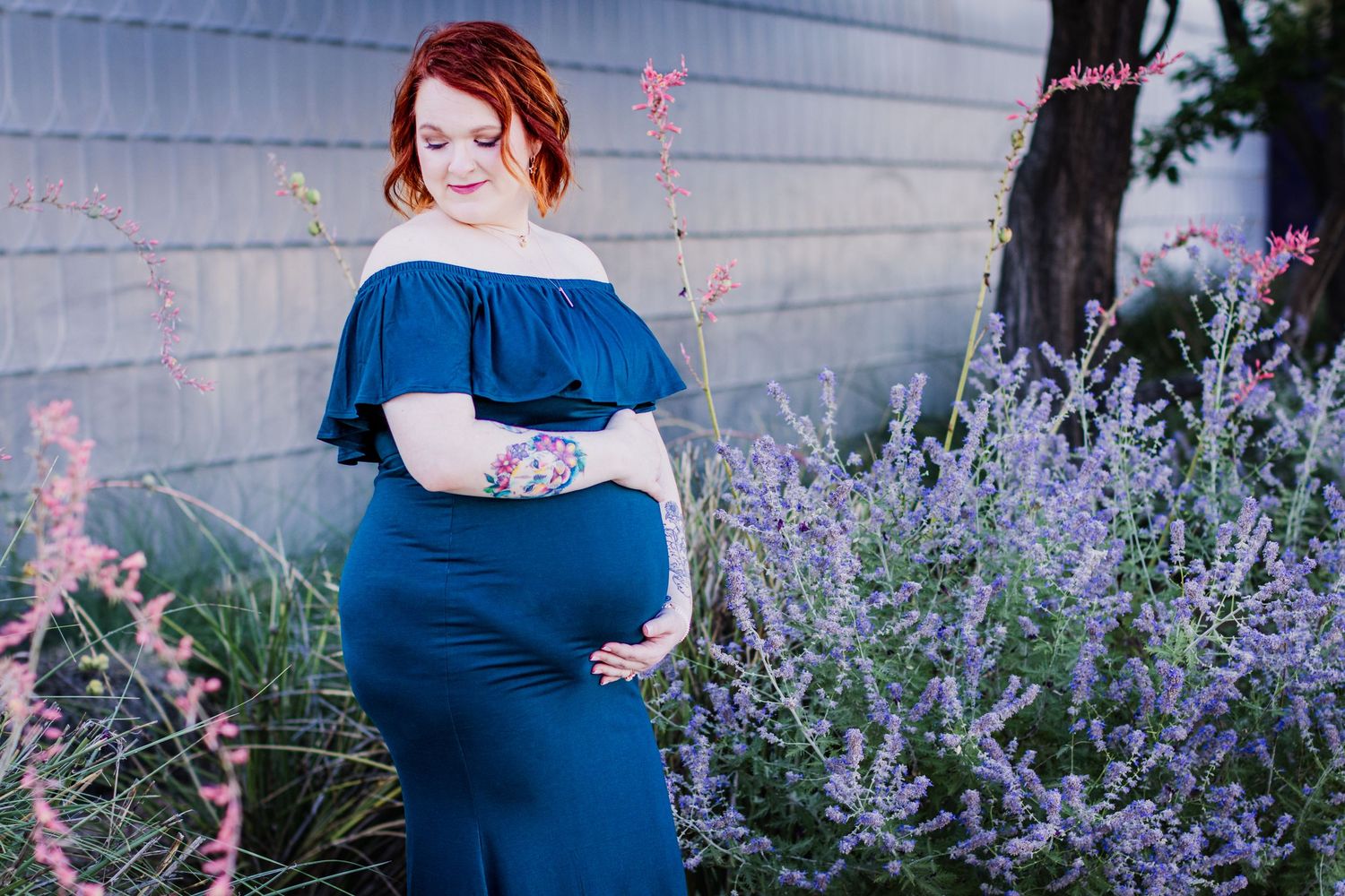 A maternity photo session among blooming purple lavender flowers on a sunny day.